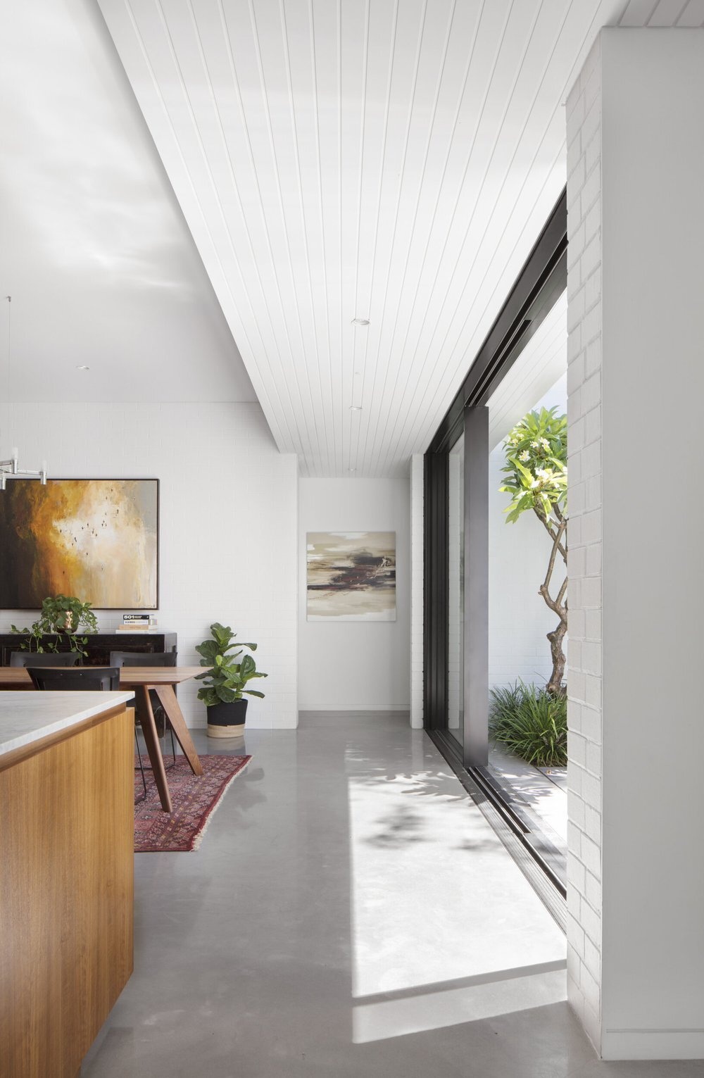 The kitchen and dining room opens entirely to the backyard through concealed sliding glass doors for seamless indoor-outdoor living.