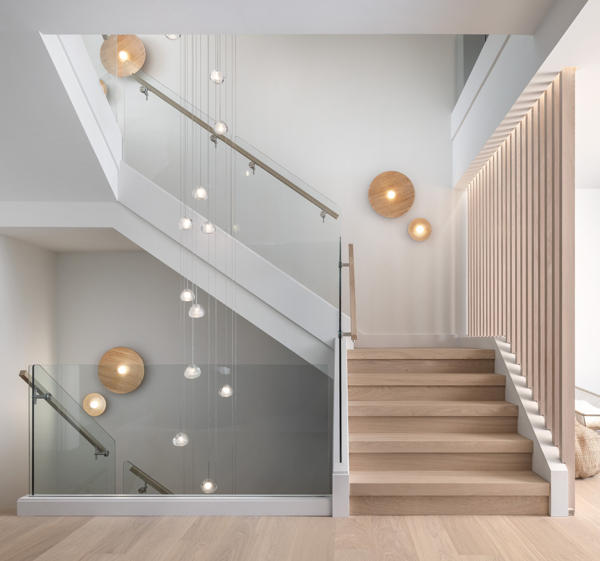 Glass, vertical slats, and floating treads make the staircase a daily sculpture. It filters light across floors and ties the home’s calm geometry together. It is a photograph waiting to happen from every angle.