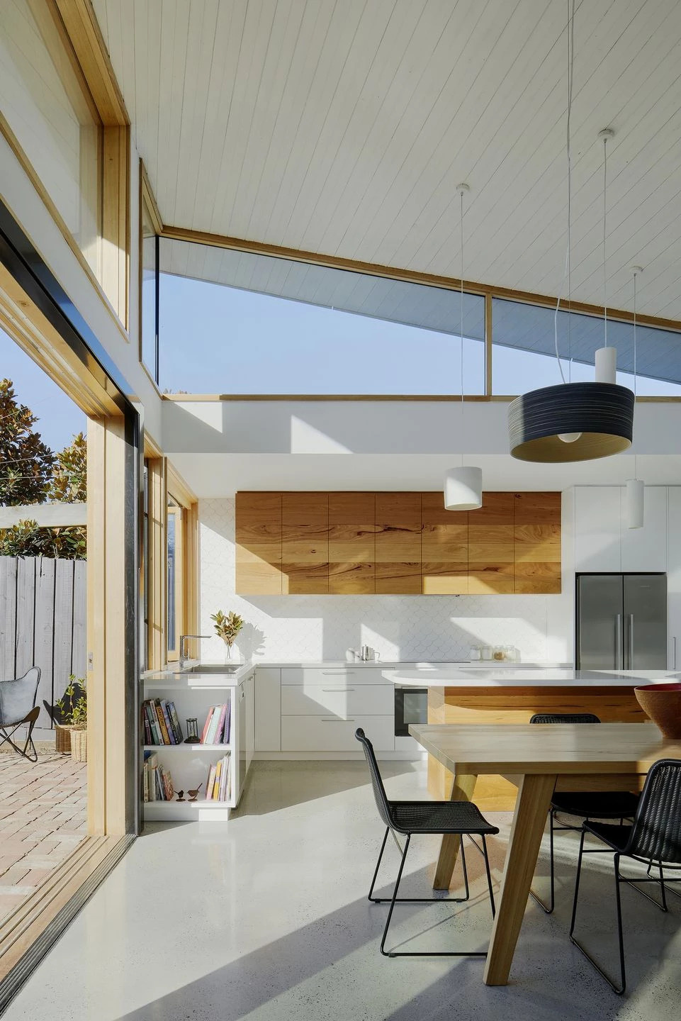 A kitchen window opens to a recycled brick patio, turning into a bar for easy outdoor entertaining, the essence of Australian indoor-outdoor living.