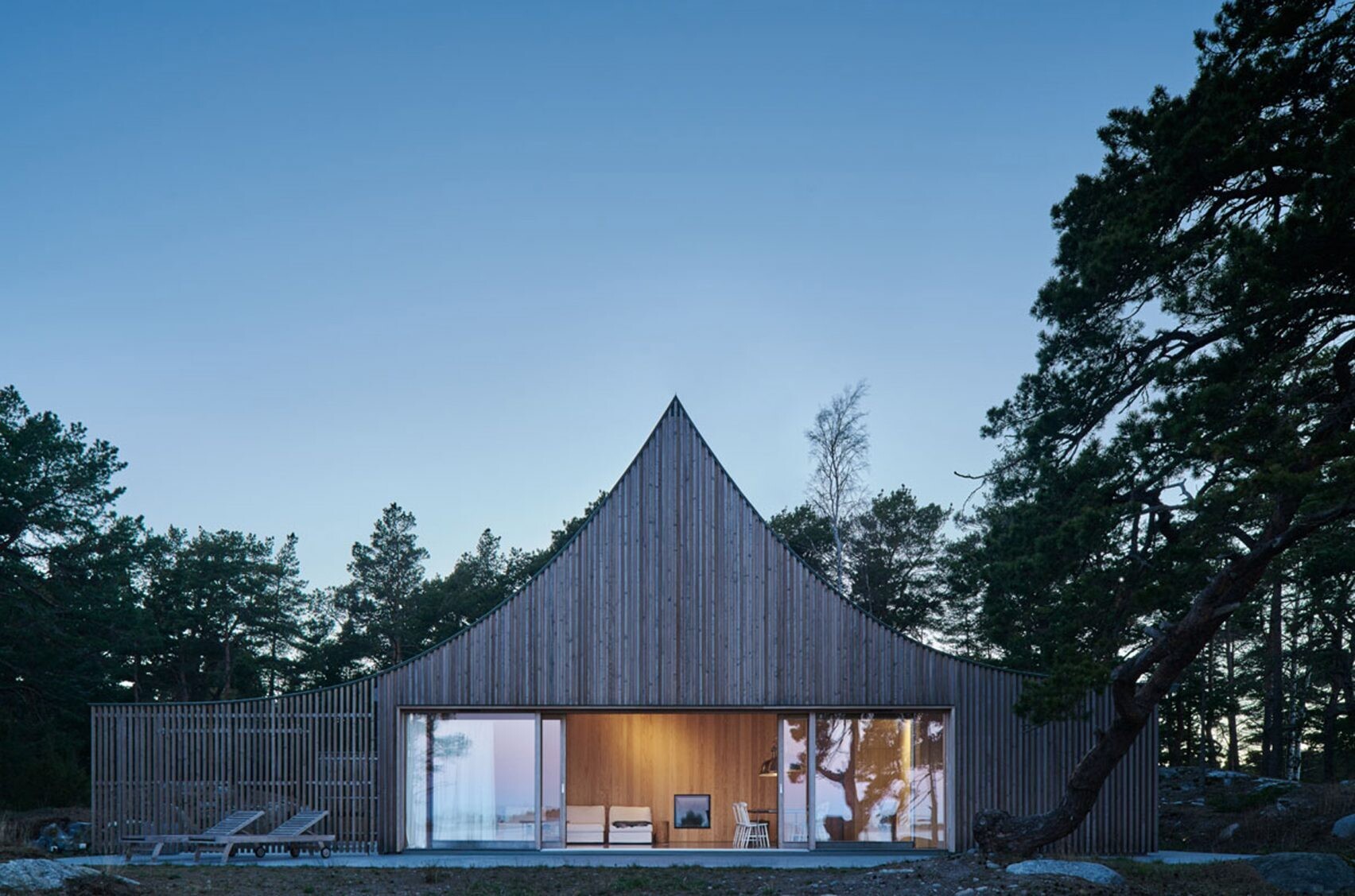 Set against the Baltic Sea, the cedar facade and curved roof of this island retreat create a timeless connection to the rugged Scandinavian landscape.