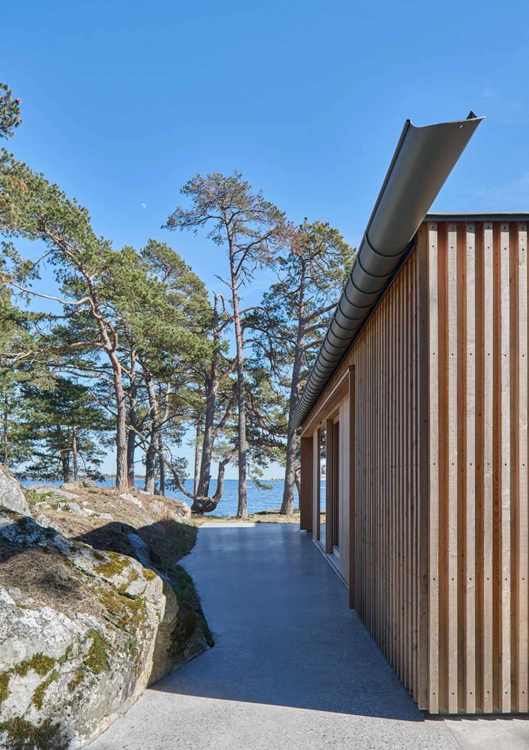 Set against the Baltic Sea, the cedar facade and curved roof of this island retreat create a timeless connection to the rugged Scandinavian landscape.