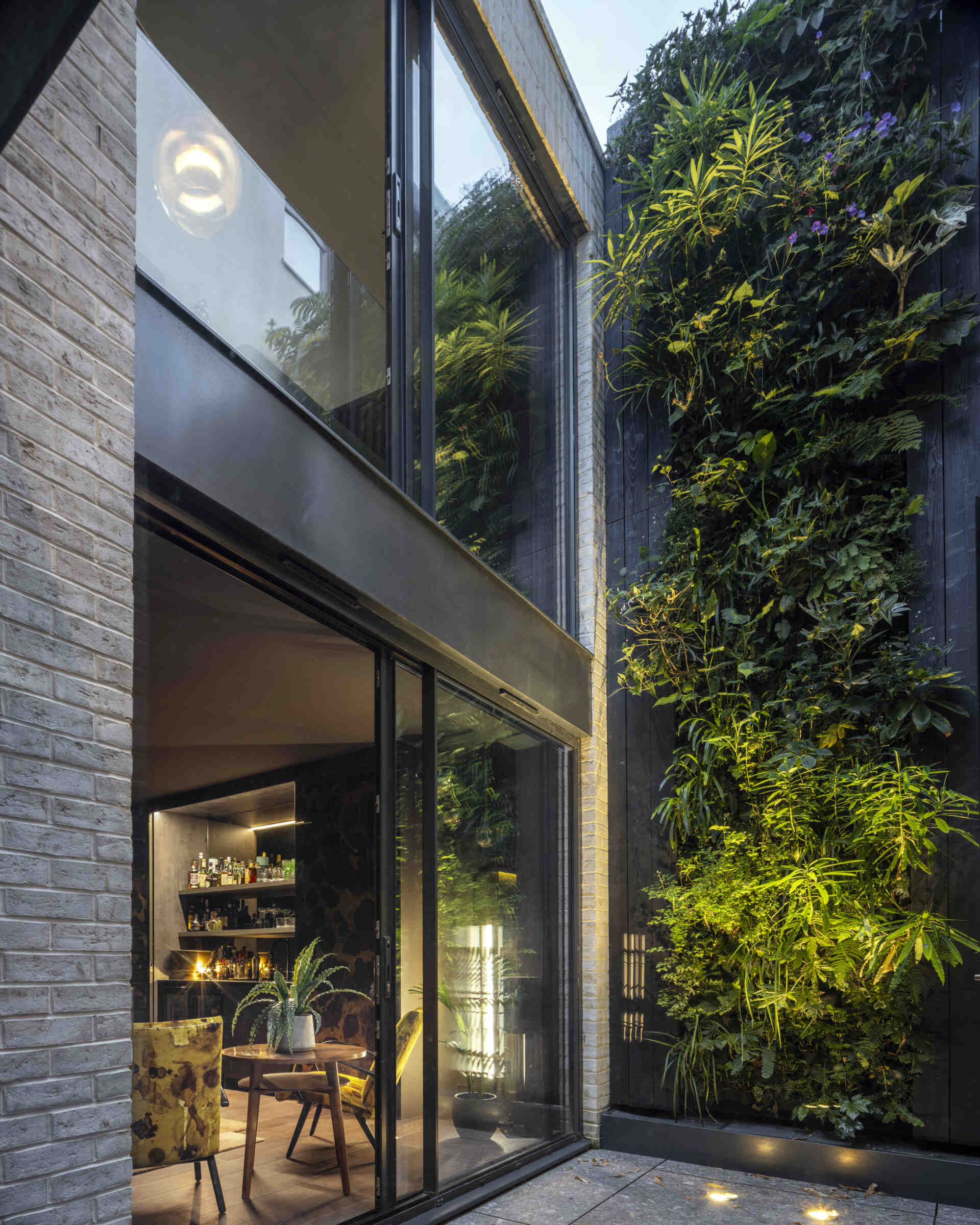 The basement opens directly onto a private sunken courtyard, a rare feature in London homes. Lush planting and natural textures create a sense of retreat while maintaining connection to the upper levels.