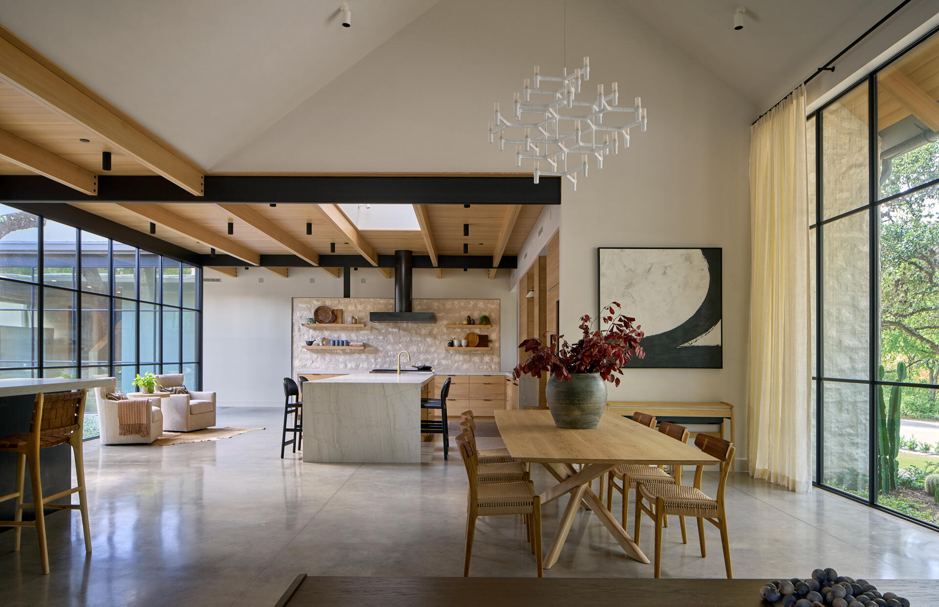 The open plan dining area benefits from the home’s central courtyard, drawing in tree-filtered light that softens the atmosphere.