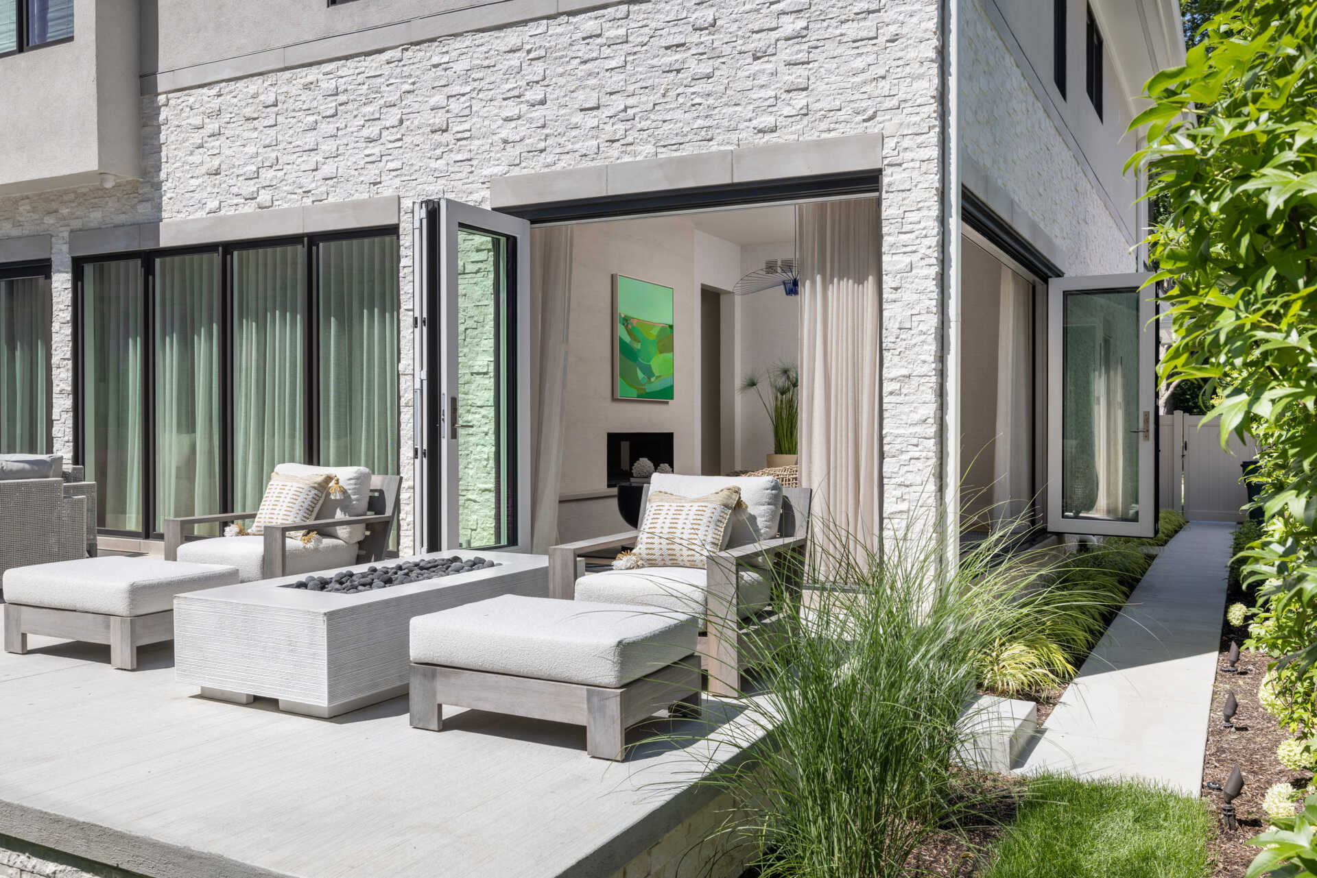 Slide the glass wide and the living space keeps going. The lanai picks up the home’s palette, so there is no harsh break between inside and out. You get firepit nights, breezy lunches, and that rare sense that the house is relaxing with you.