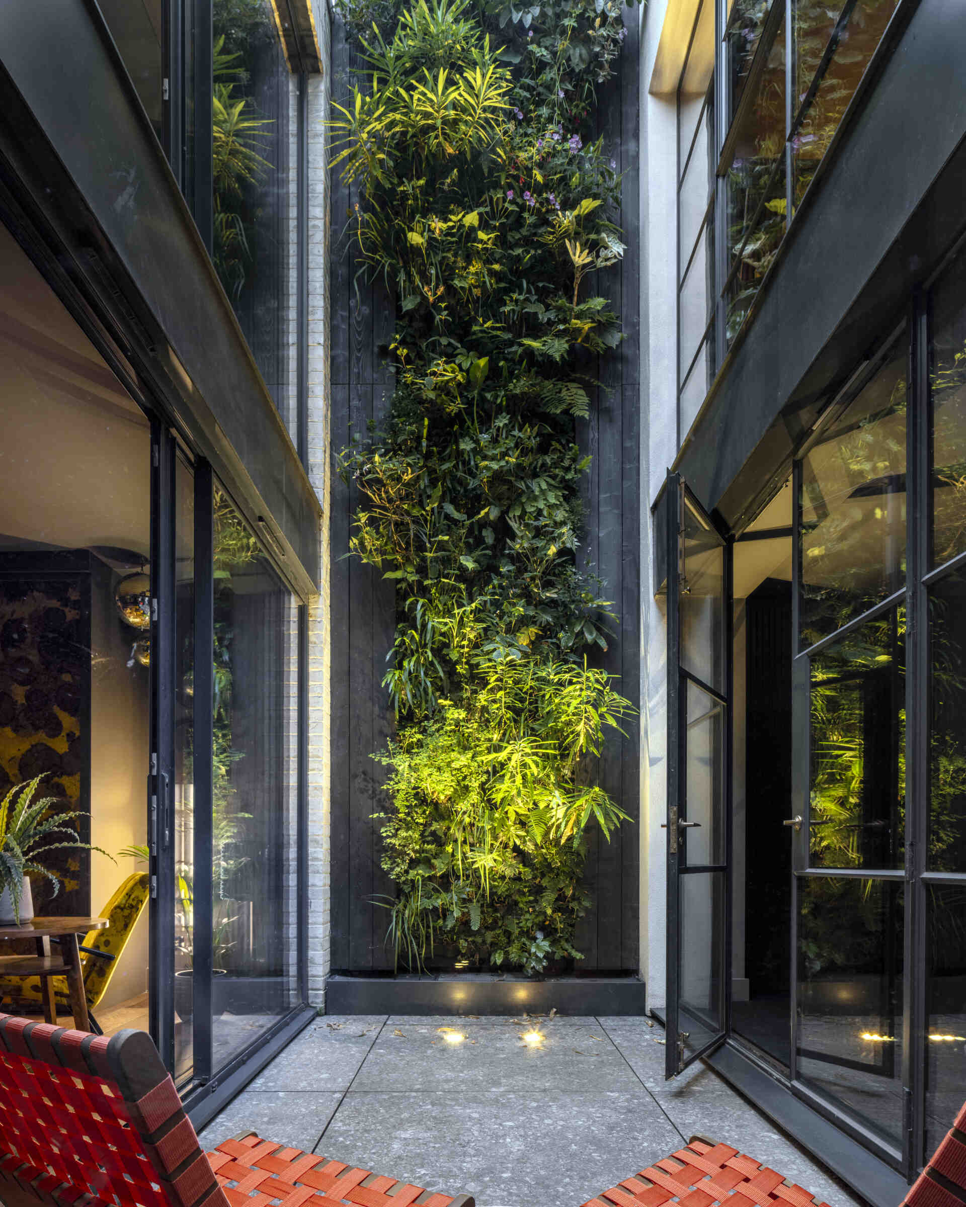 The basement opens directly onto a private sunken courtyard, a rare feature in London homes. Lush planting and natural textures create a sense of retreat while maintaining connection to the upper levels.