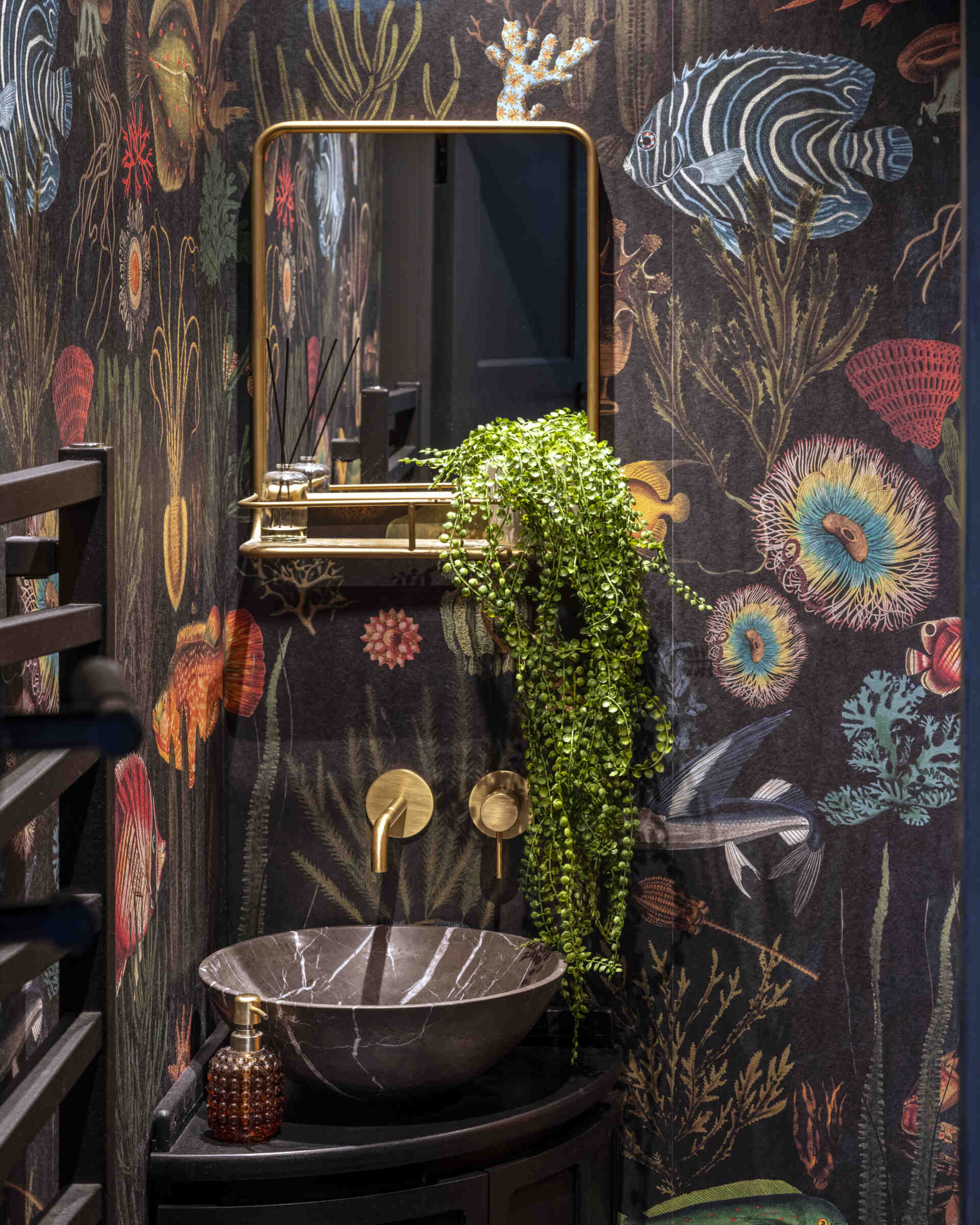 Powder rooms wrapped in patterned wallpaper bring a joyful twist to the home’s calm interiors.