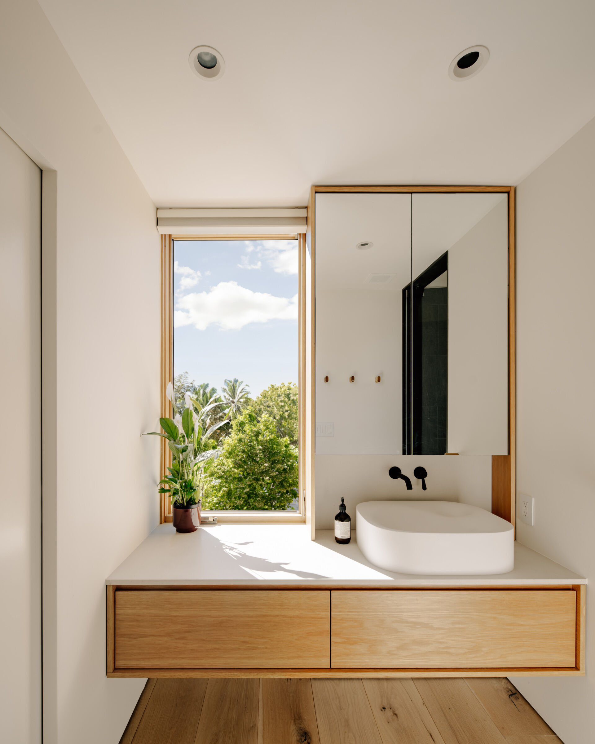 The upper floor houses the primary suite with a slate-clad wet room. A Japanese Ofuro soaking tub creates a tranquil retreat, blending minimalist design with sensory appeal. This suite emphasizes comfort and private indulgence within the compact footprint.