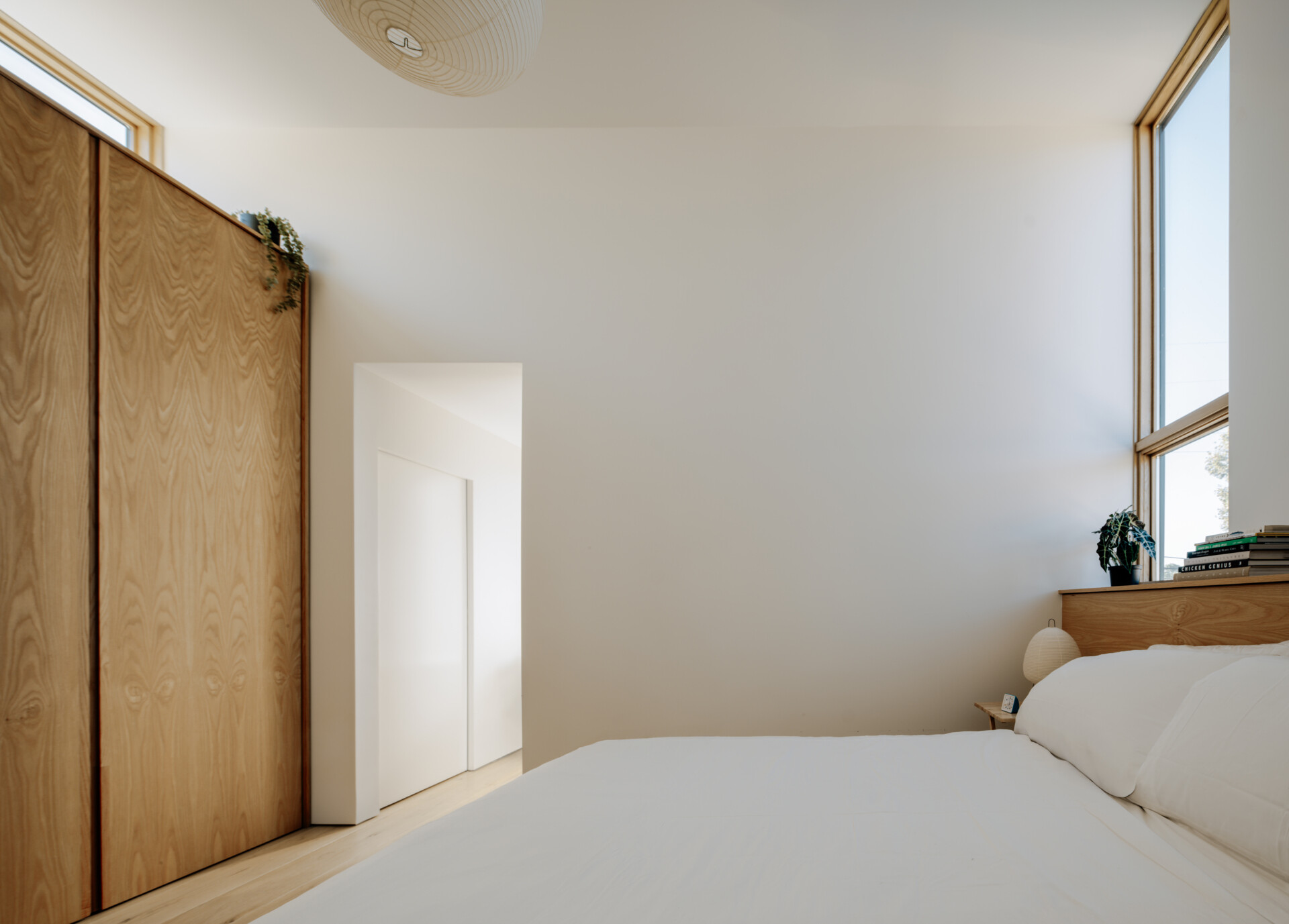 The upper floor houses the primary suite with a slate-clad wet room. A Japanese Ofuro soaking tub creates a tranquil retreat, blending minimalist design with sensory appeal. This suite emphasizes comfort and private indulgence within the compact footprint.
