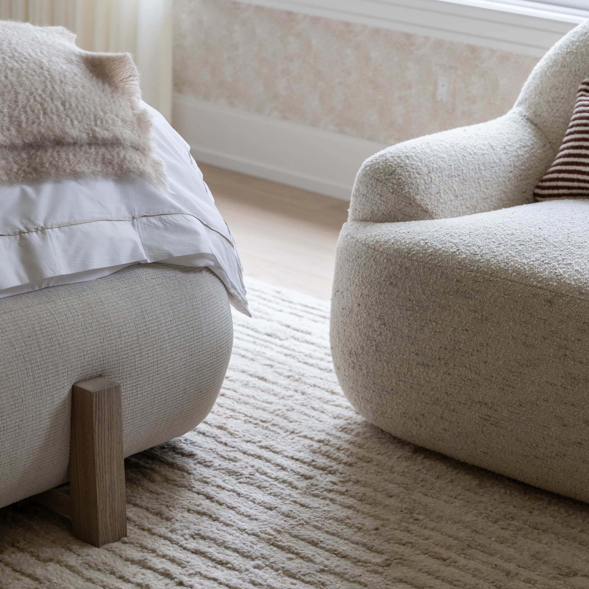 The primary bedroom keeps the palette hushed. Rounded edges, warm lamps, and upholstered textures dial up the comfort. It is generous without feeling grand. The real showpiece waits just beyond.