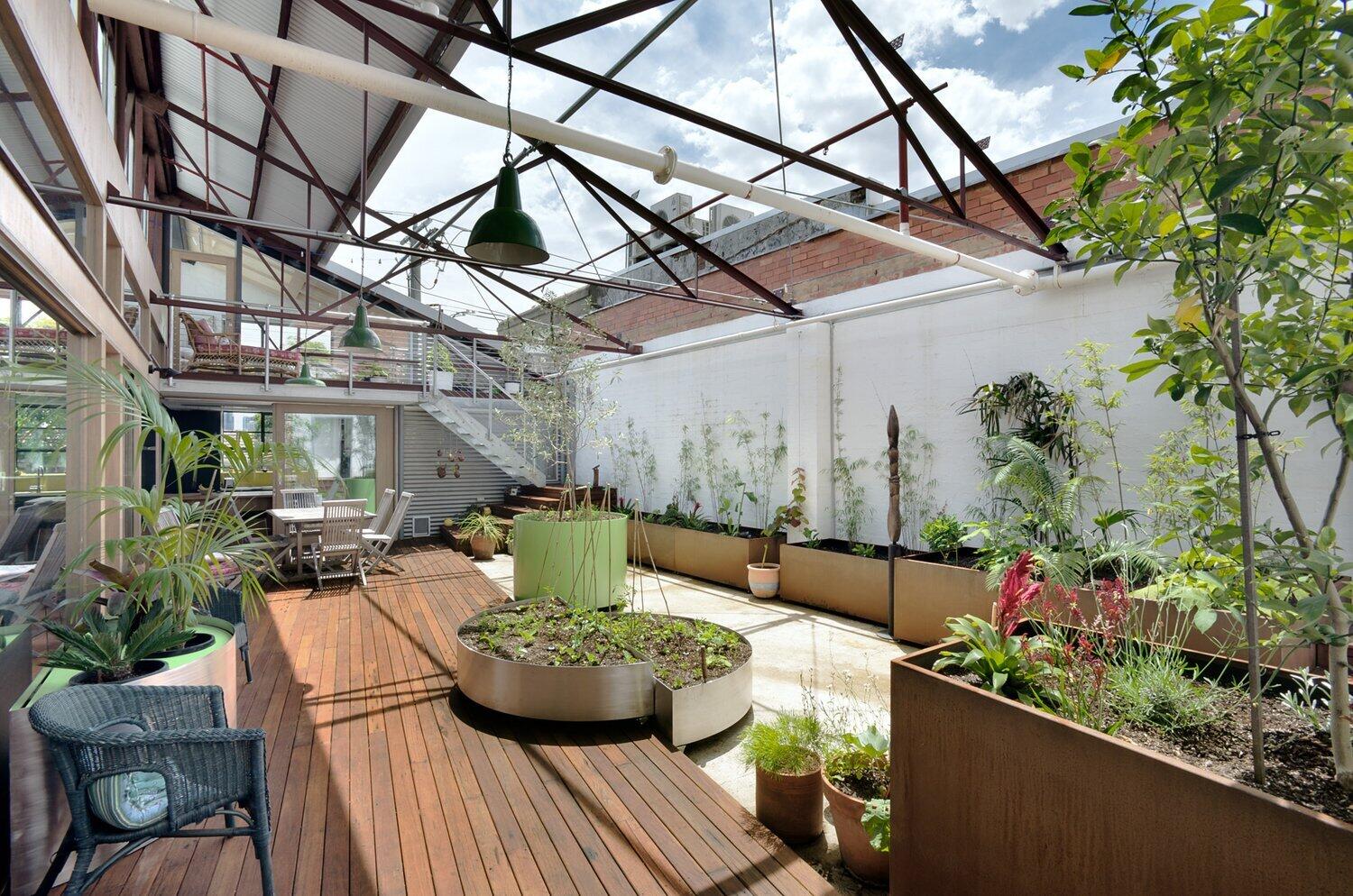 Sunlit courtyard and raised wood deck create a seamless connection between indoor and outdoor living in this converted Melbourne warehouse.