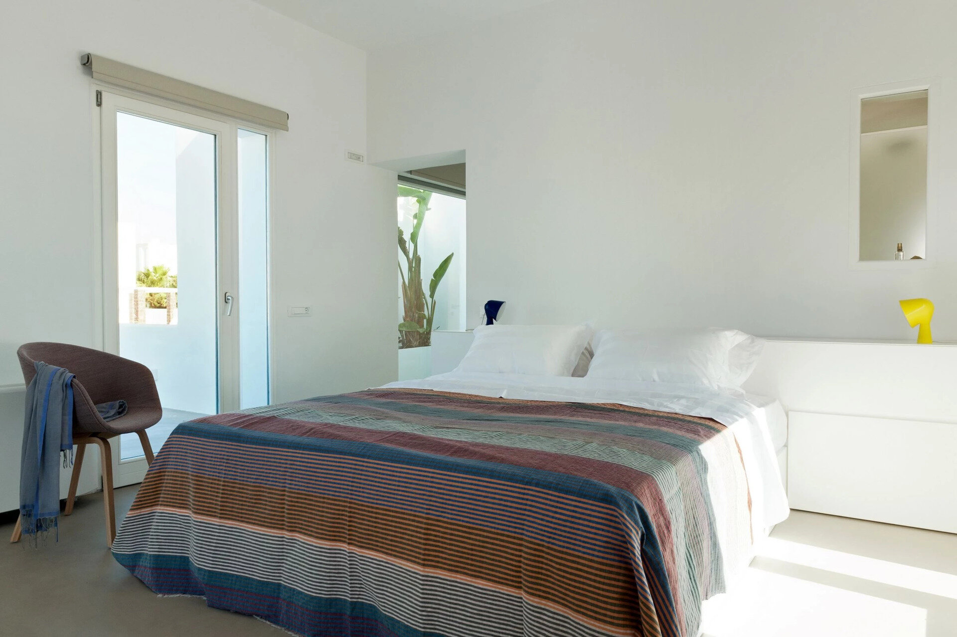 Upstairs, the master bedroom opens to a private terrace with serene island views. The design balances privacy, simplicity, and open air living.