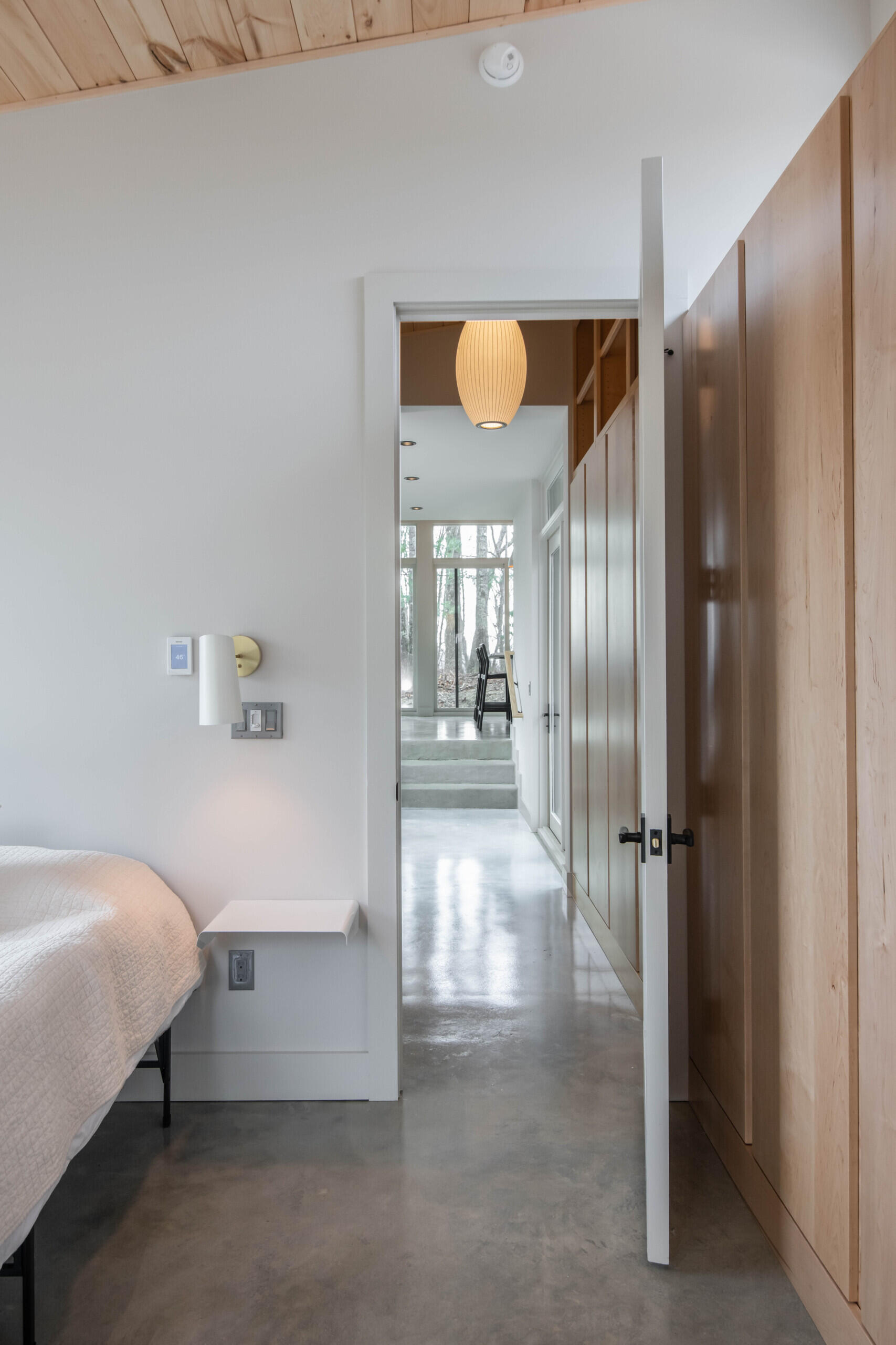East-facing primary bedroom with a built-in desk, combining work and rest in a serene mountain-modern setting.
