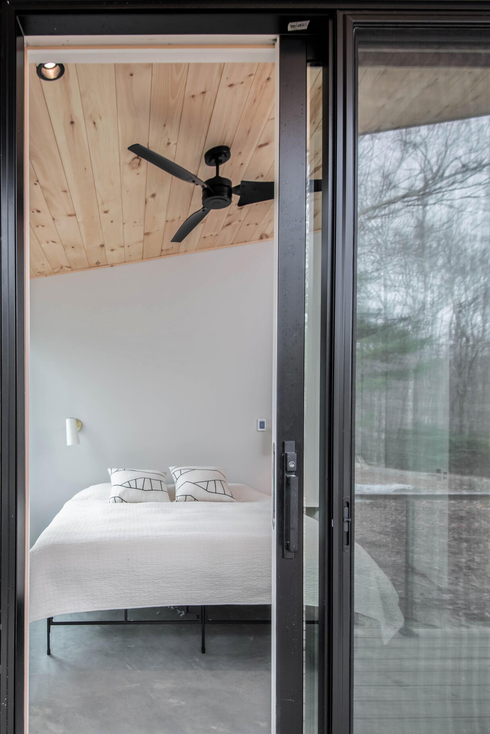 East-facing primary bedroom with a built-in desk, combining work and rest in a serene mountain-modern setting.