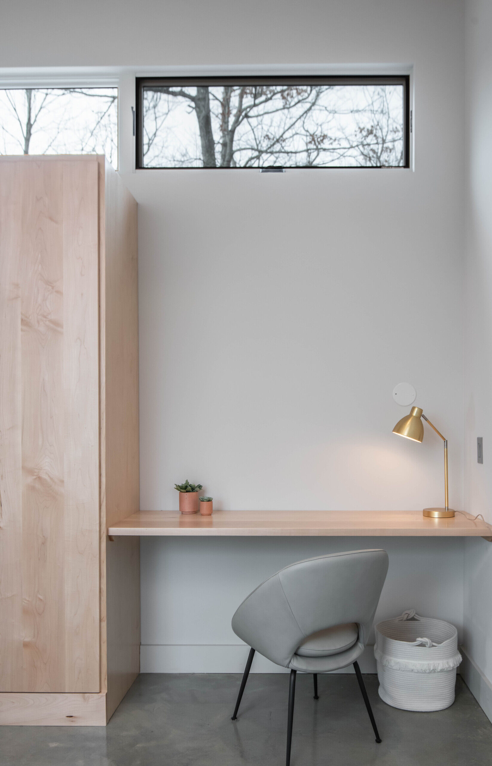 East-facing primary bedroom with a built-in desk, combining work and rest in a serene mountain-modern setting.
