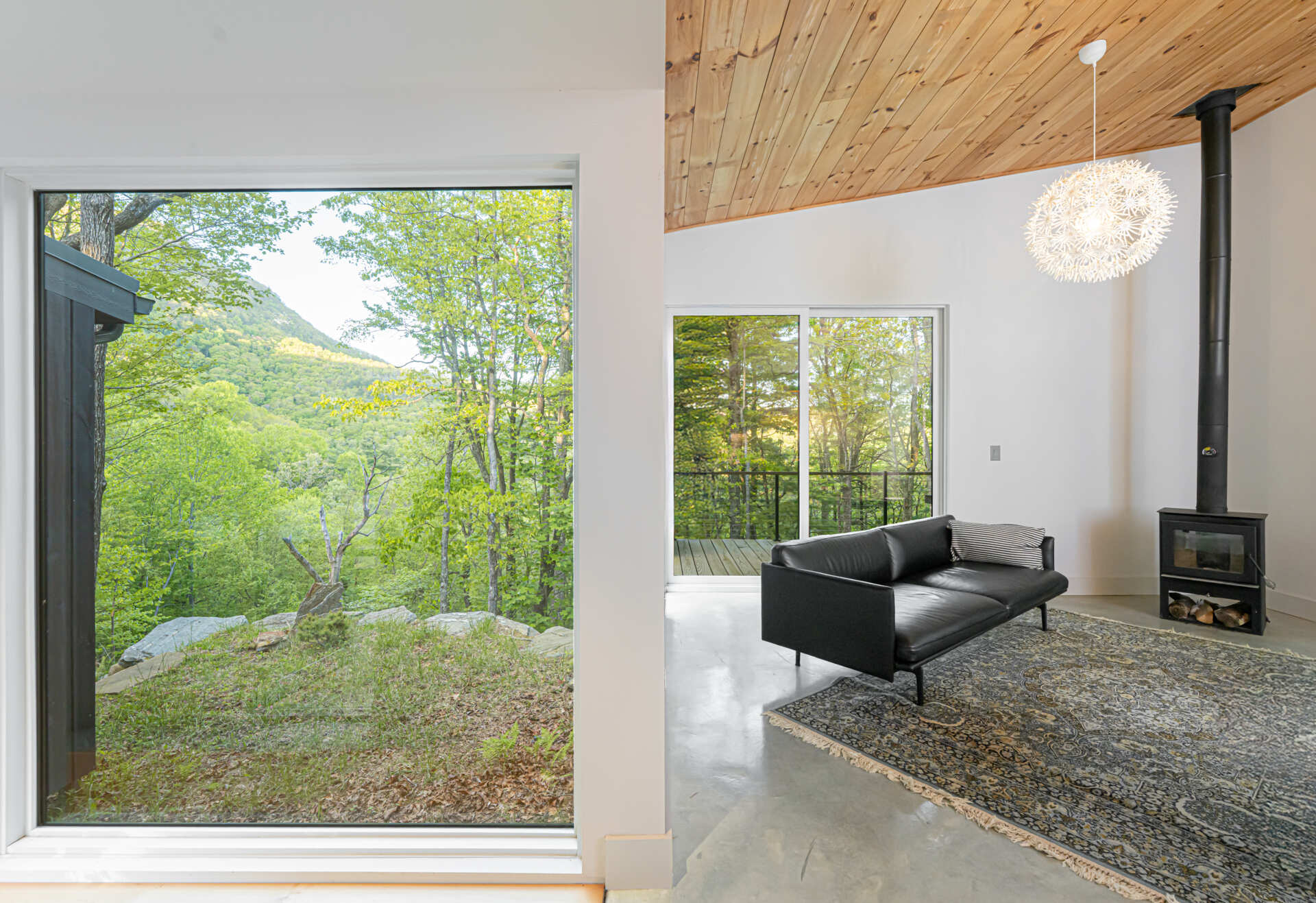 Open-plan living room with covered decks that frame mountain views, blending indoor comfort with outdoor scenery.
