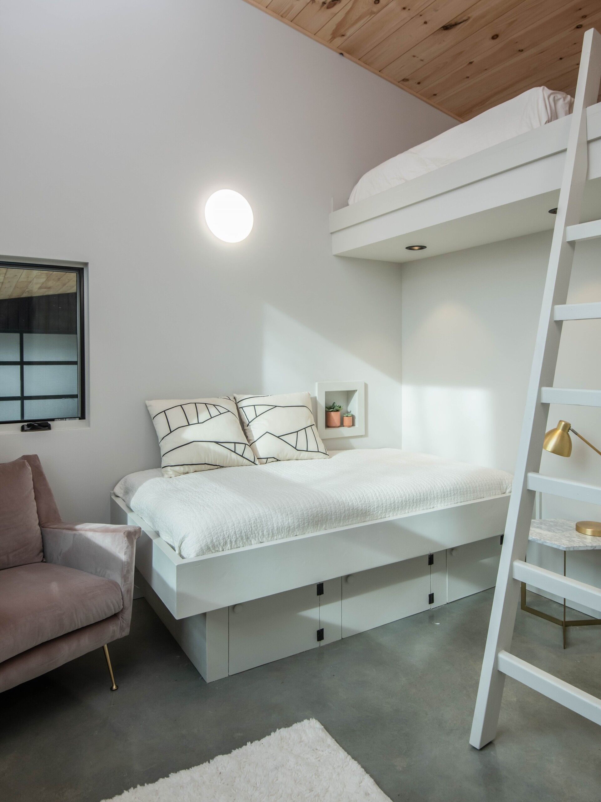 Loft bedroom in a mountain cabin, maximizing space and light while maintaining minimalist, family-friendly design.
