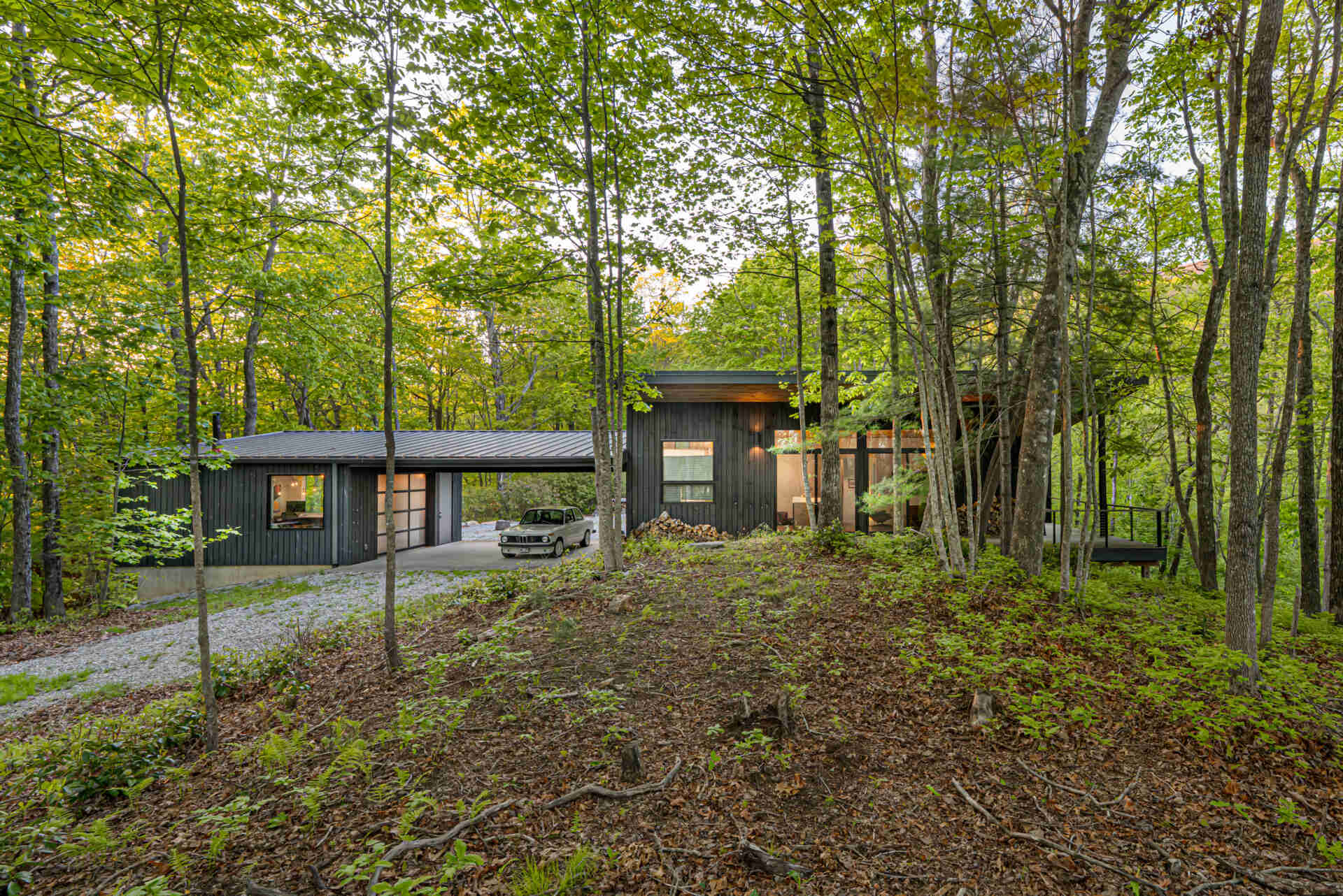The garage doubles as a flexible space, serving as a carport, office, and a playful area for tinkering or projects. Positioned strategically along the logging road, it balances function and form, creating a practical yet inviting entry point to the property.