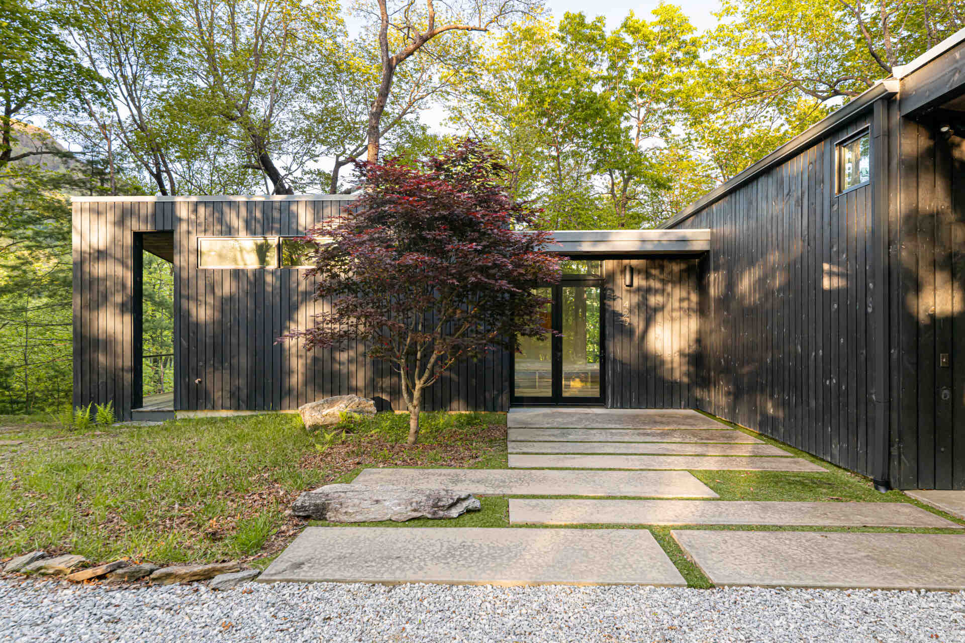 The main entry is tucked along the east-facing pavilion, providing a quiet, welcoming approach separate from the home's busier living areas. This thoughtful placement gives the family a sense of arrival while preserving privacy and tranquility.