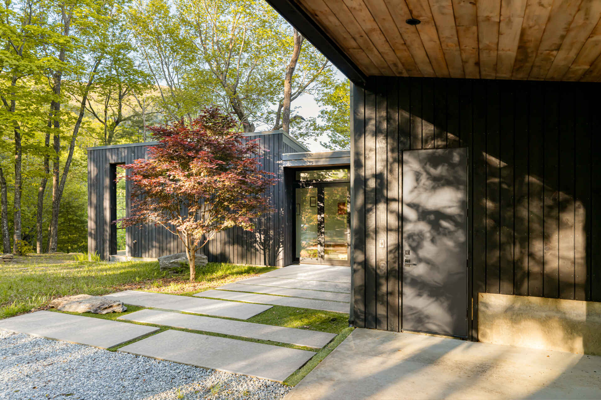 The main entry is tucked along the east-facing pavilion, providing a quiet, welcoming approach separate from the home's busier living areas. This thoughtful placement gives the family a sense of arrival while preserving privacy and tranquility.