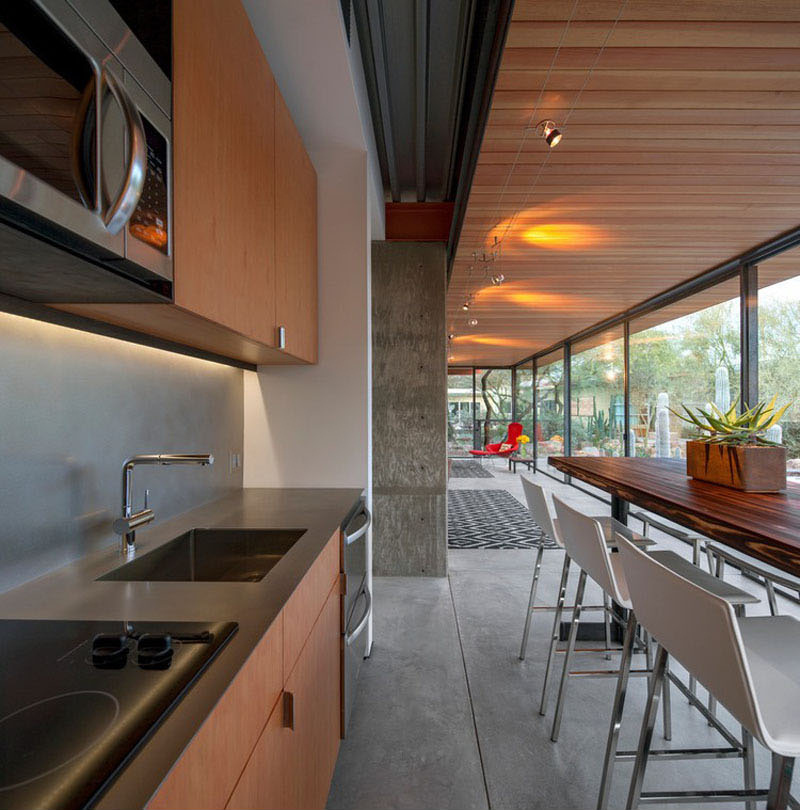 A minimalist kitchen with a long bar table offers all the essentials, with views that connect directly to the desert garden outside.