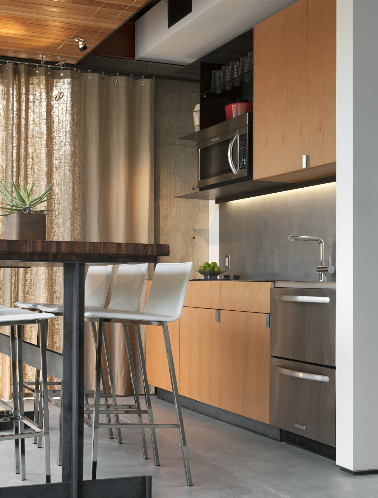 A minimalist kitchen with a long bar table offers all the essentials, with views that connect directly to the desert garden outside.