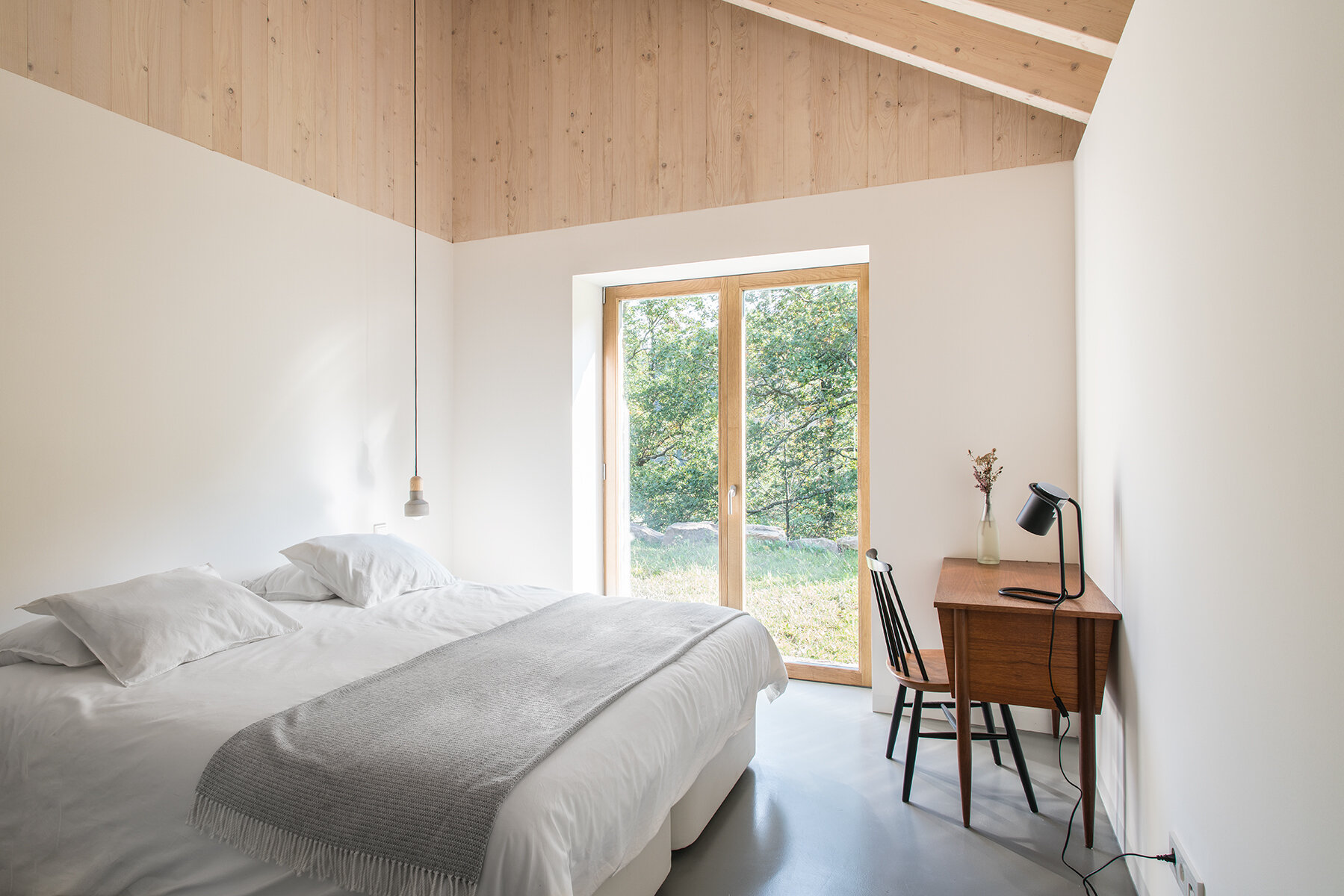 A modern yet minimal bedroom with a loft above the bathroom and closet.