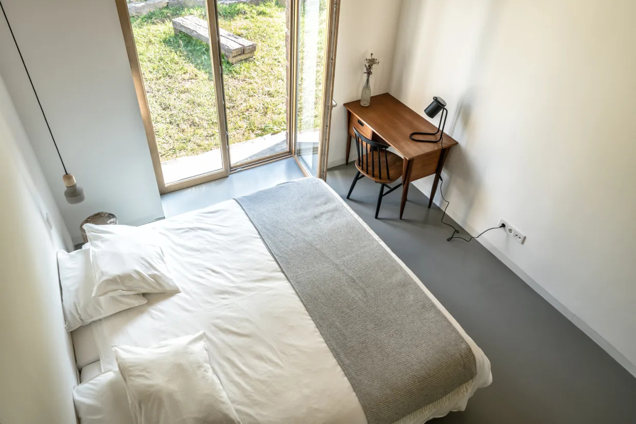 A modern yet minimal bedroom with a loft above the bathroom and closet.