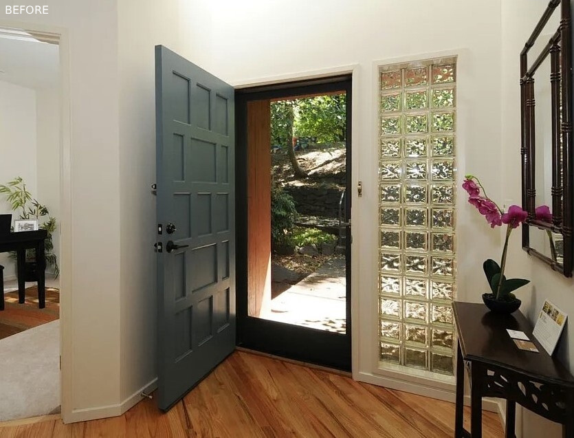 BEFORE - A winding path approaches from the east, weaving between alder trees before rising to an elevated deck that meets the front porch, where a soft yellow front door greets visitors. Natural light filters through dense greenery to the south, creating a soft welcome as you enter.