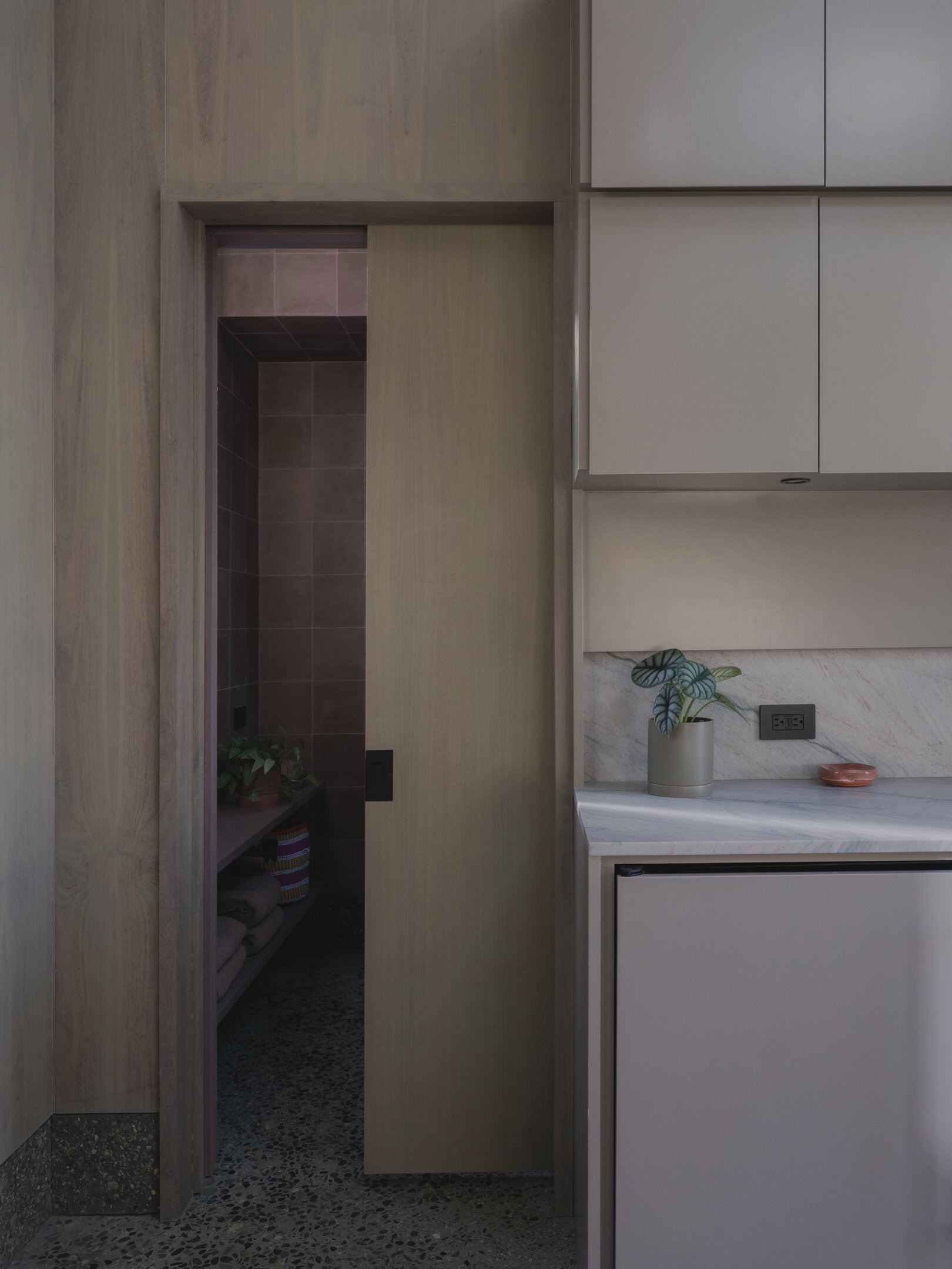 Natural stone, wood, and handmade tile come together in a small yet refined bathroom designed around light, texture, and simplicity.