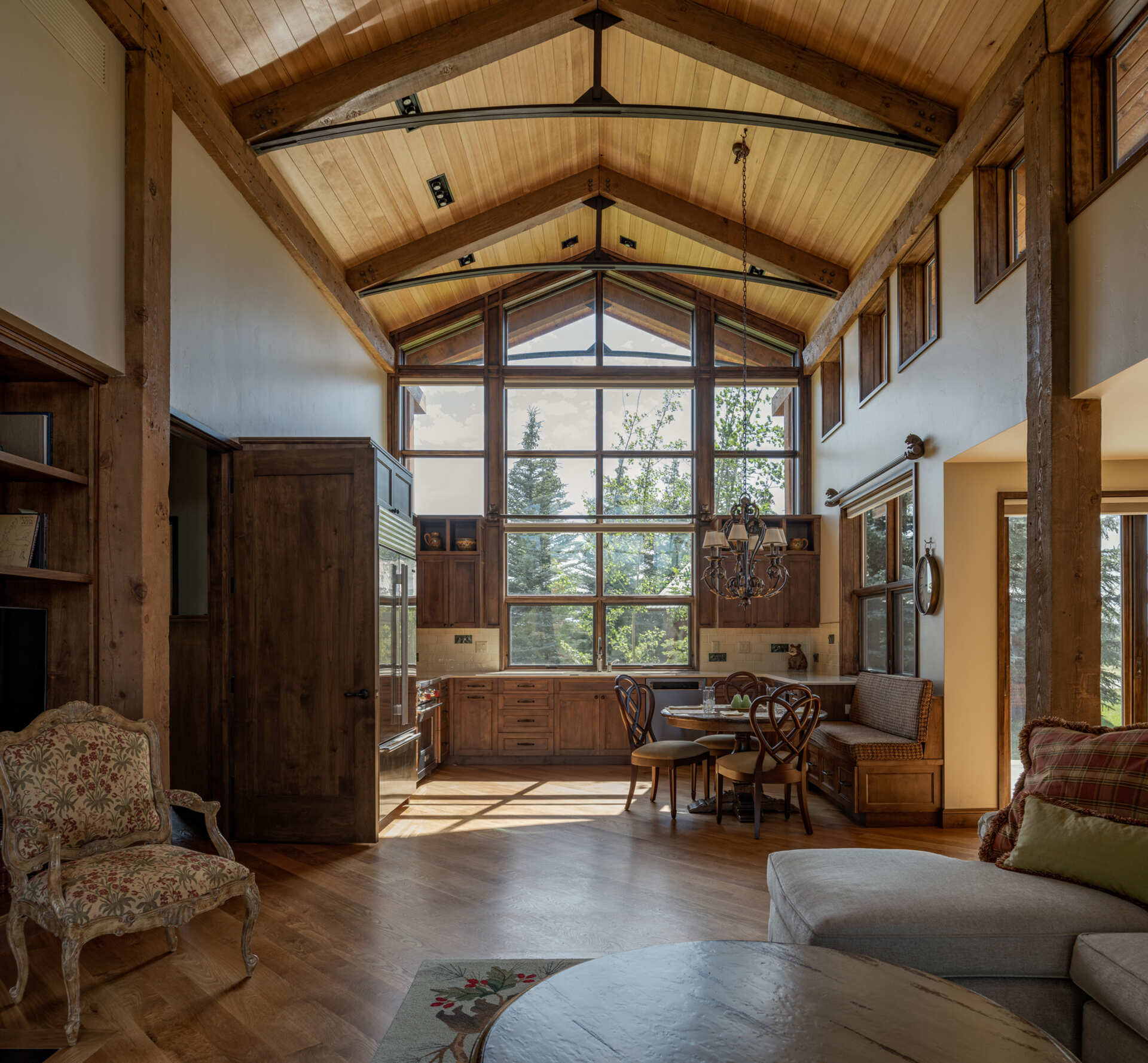 Sunlight floods the living, kitchen, and dining areas, while steel trusses, and personalized artwork add warmth and whimsy to a functional, comfortable mountain retreat.