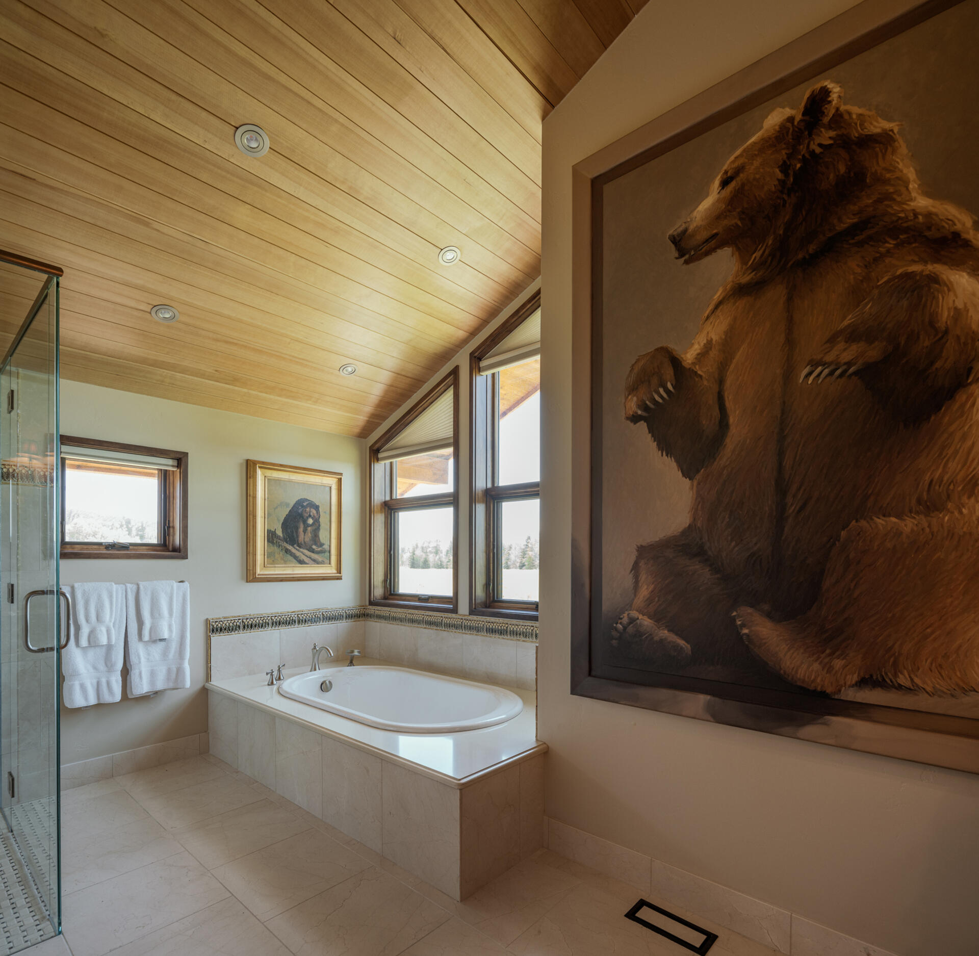 A bathroom with built-in bathtub under the windows.