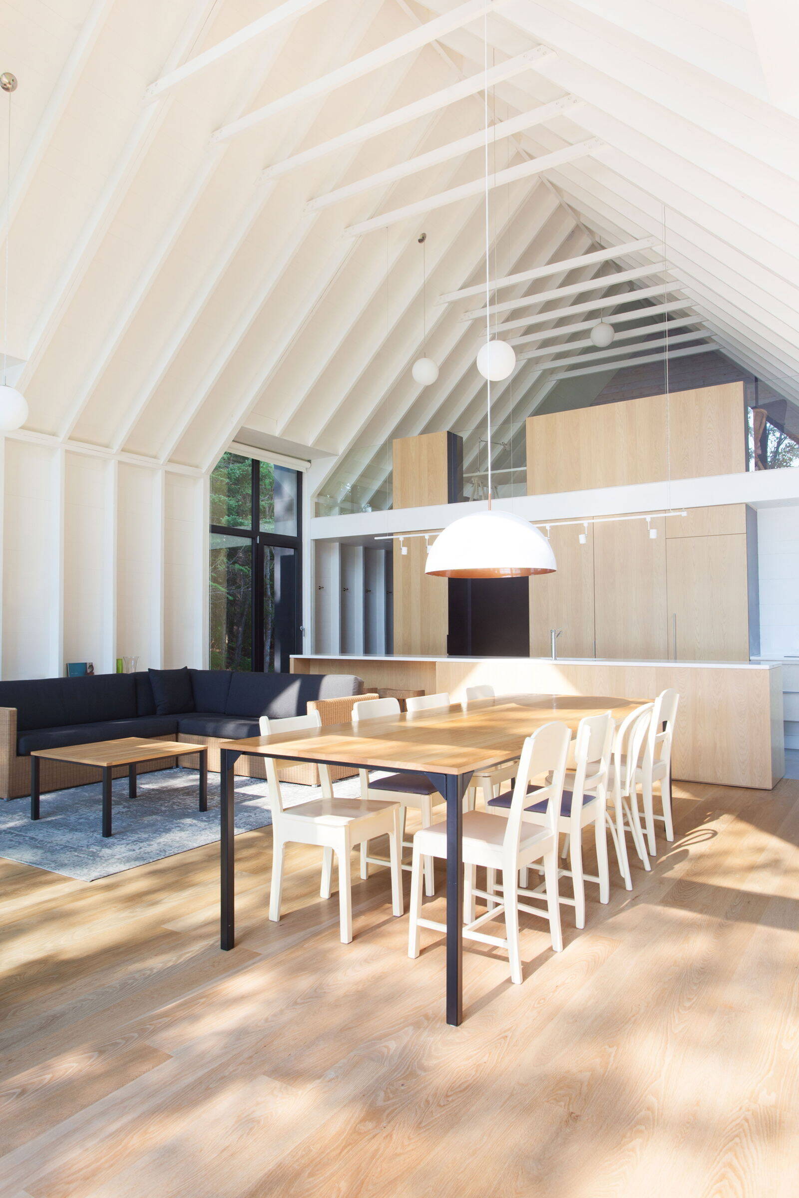 Los altos paneles de vidrio a cada lado desdibujan los límites entre la cabaña de cedro y el bosque exterior.