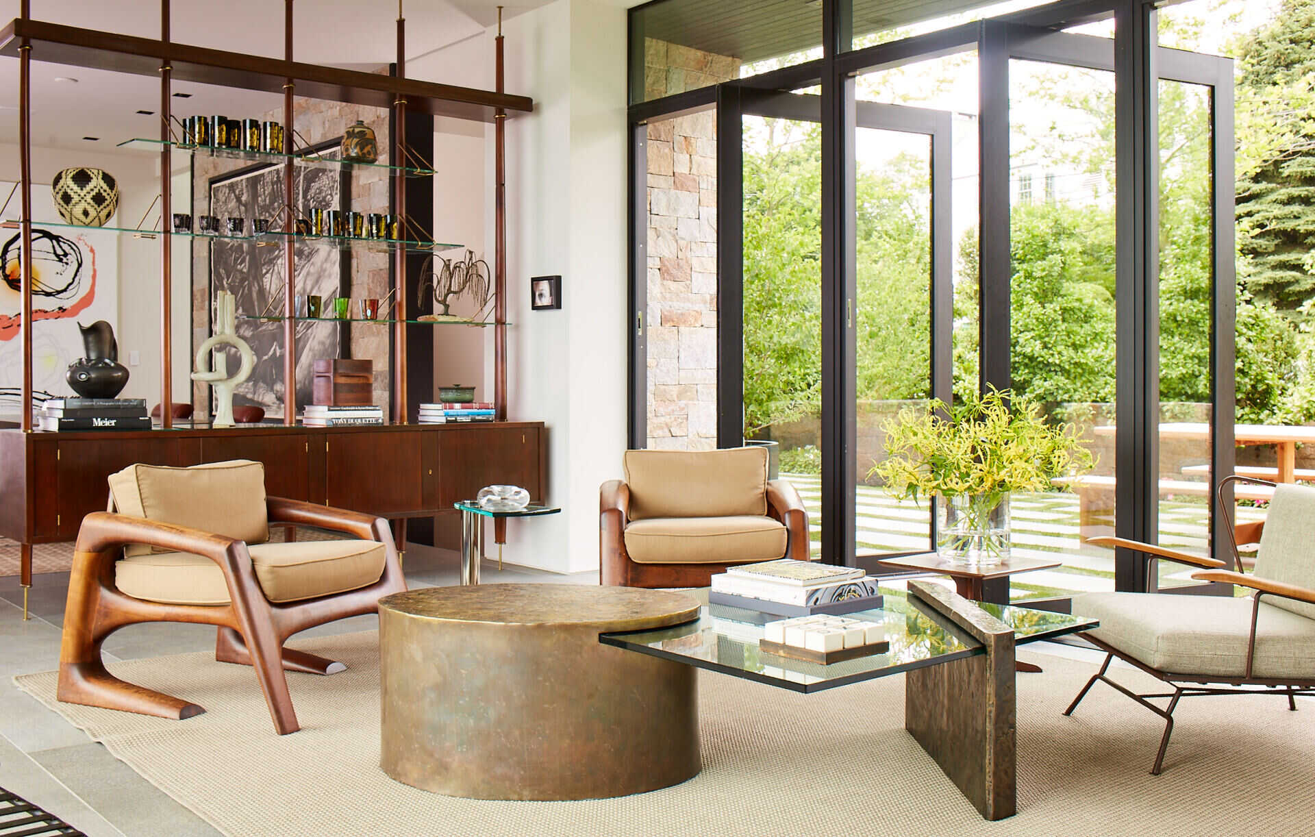 A wood and glass divider adds structure and style inside this light filled waterfront home, keeping living and dining connected yet defined.