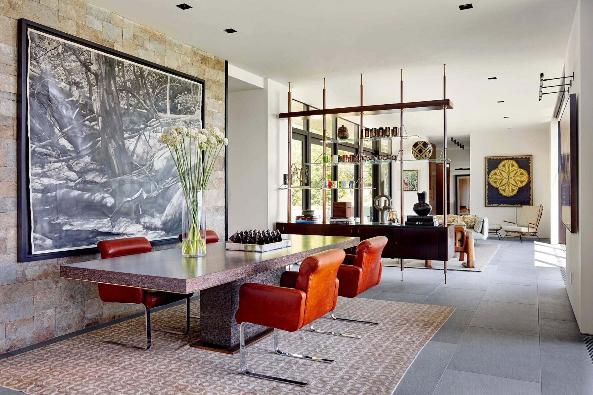 A wood and glass divider adds structure and style inside this light filled waterfront home, keeping living and dining connected yet defined.