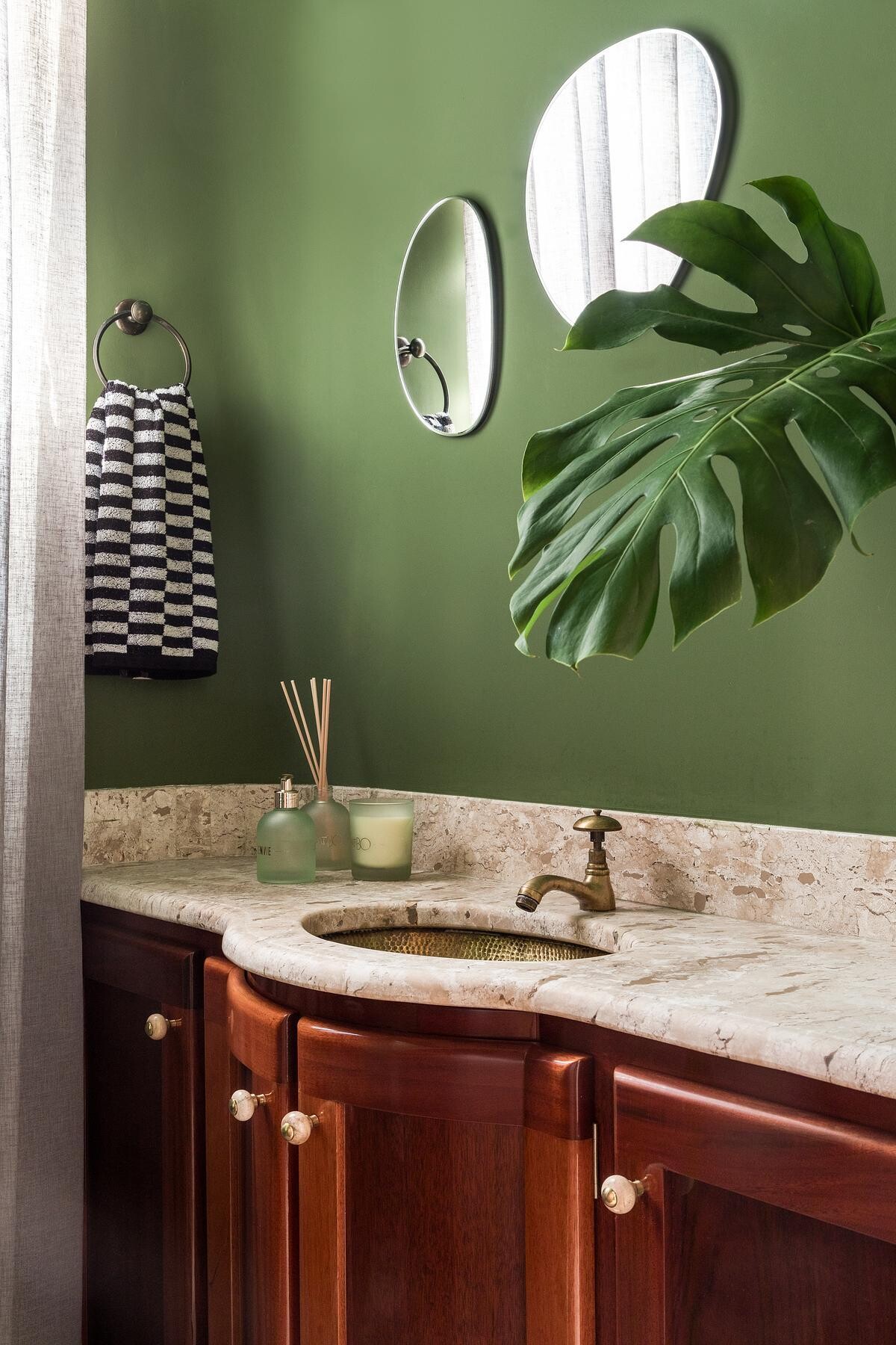 With its green walls, this powder room becomes a vivid moment inside the home.