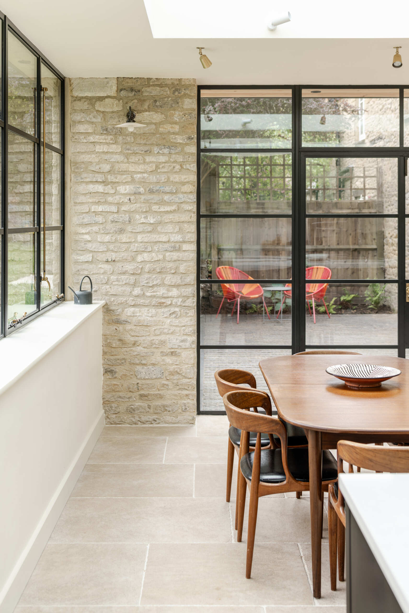 This new dining area gains natural light that moves across the space throughout the day. A historic well was uncovered during excavation. Instead of removing it, the team preserved it beneath a glass floor panel with subtle lighting. It now acts as a quiet focal point and a reminder of the site’s layered past.