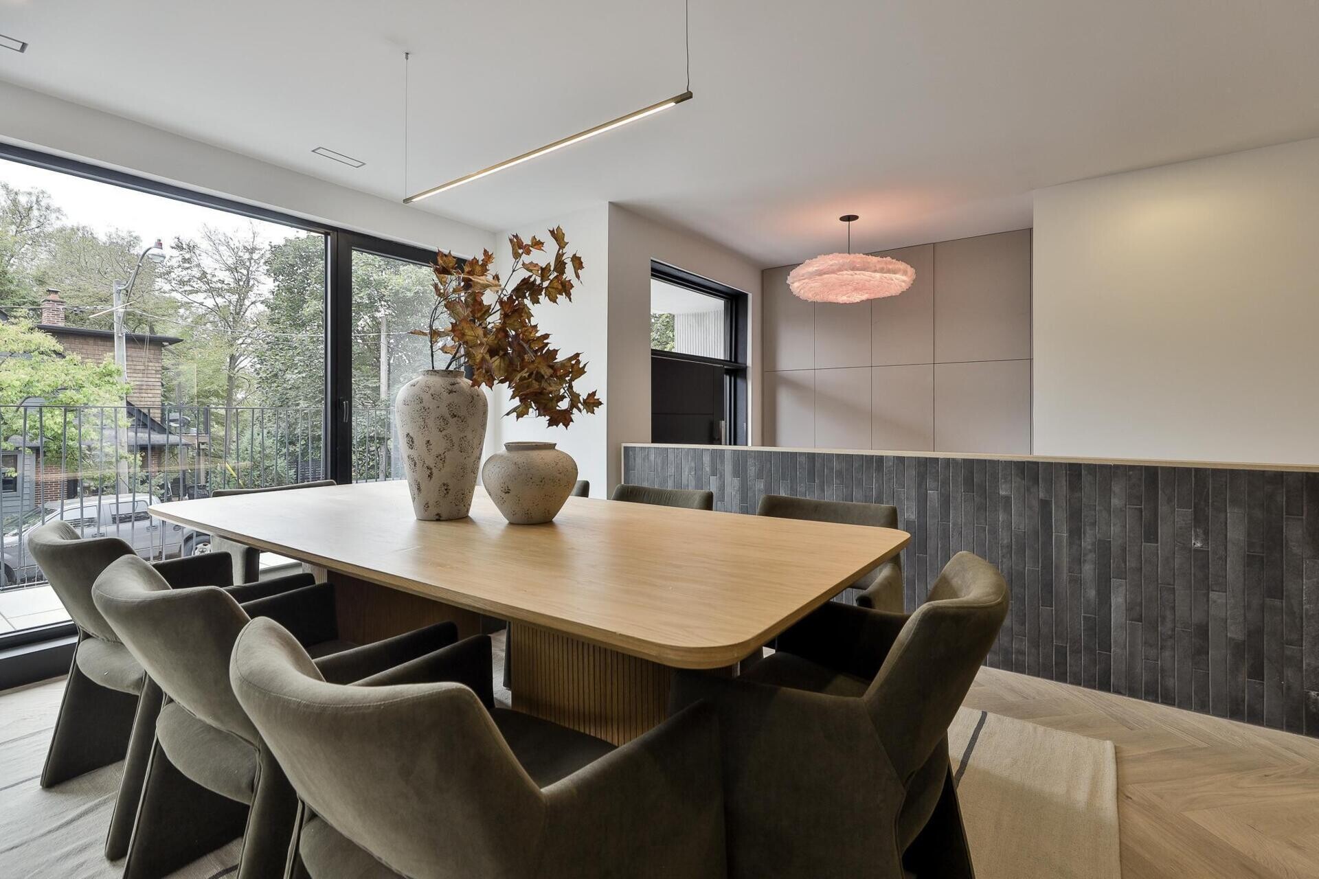 The dining area, accessed via a few steps, feels connected yet distinct, held by the warm tone of the oak cabinetry and the calm presence of the surrounding palette.