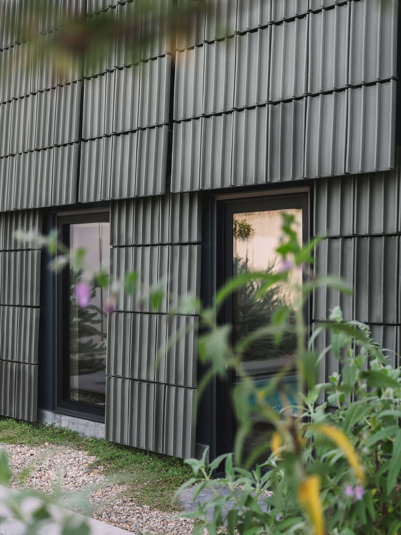 A Los Angeles ADU wrapped in green terracotta tiles transforms a forgotten backyard into an architectural statement, celebrating material craft and the beauty of shadow and texture.