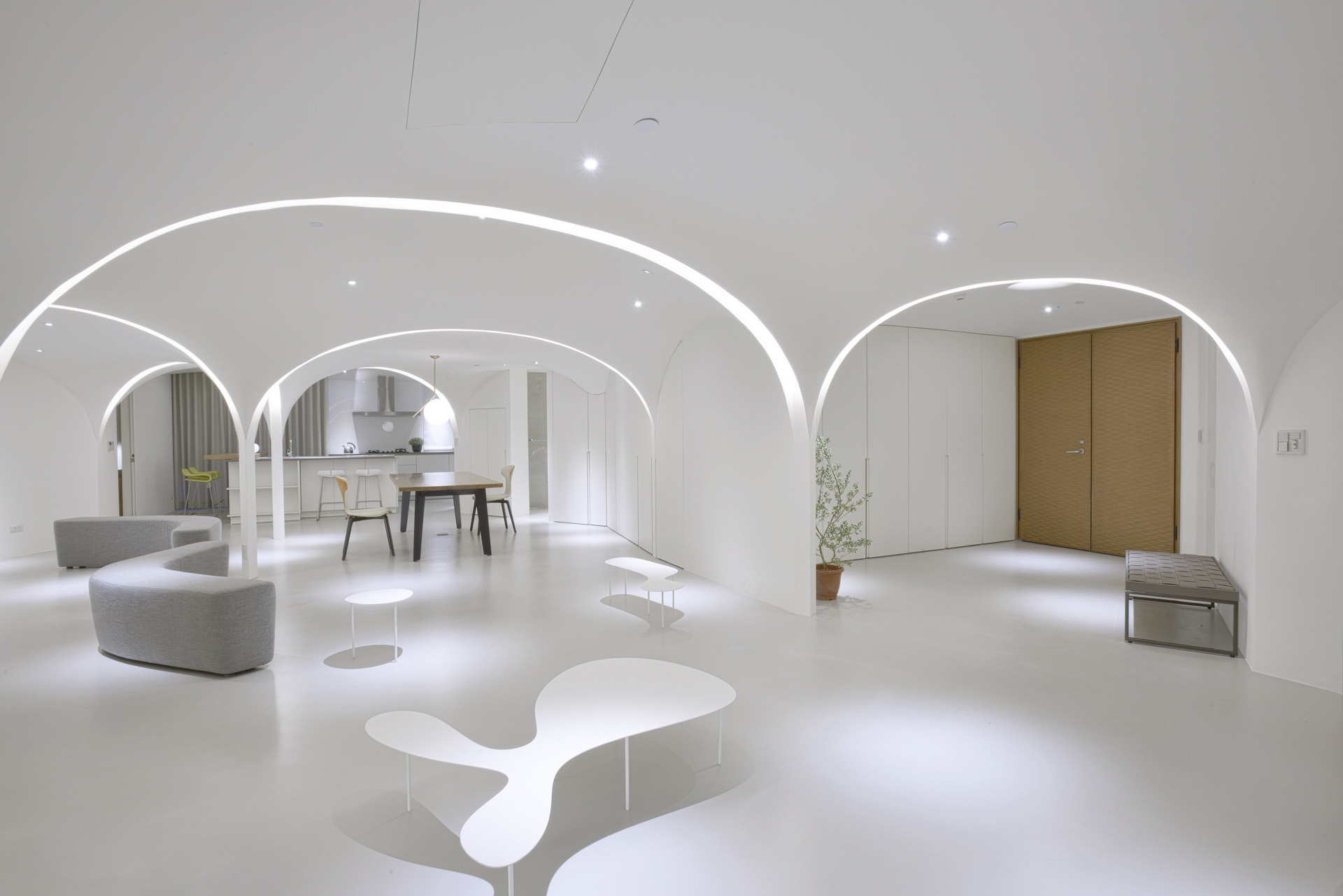 A soft white apartment in Taichung transformed with arches, curves and a reimagined flow that brings sunlight deep into the home.