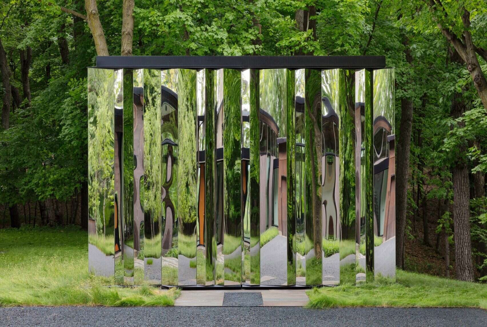 A reflective storage shed that melts into the woods with mirrored surfaces.
