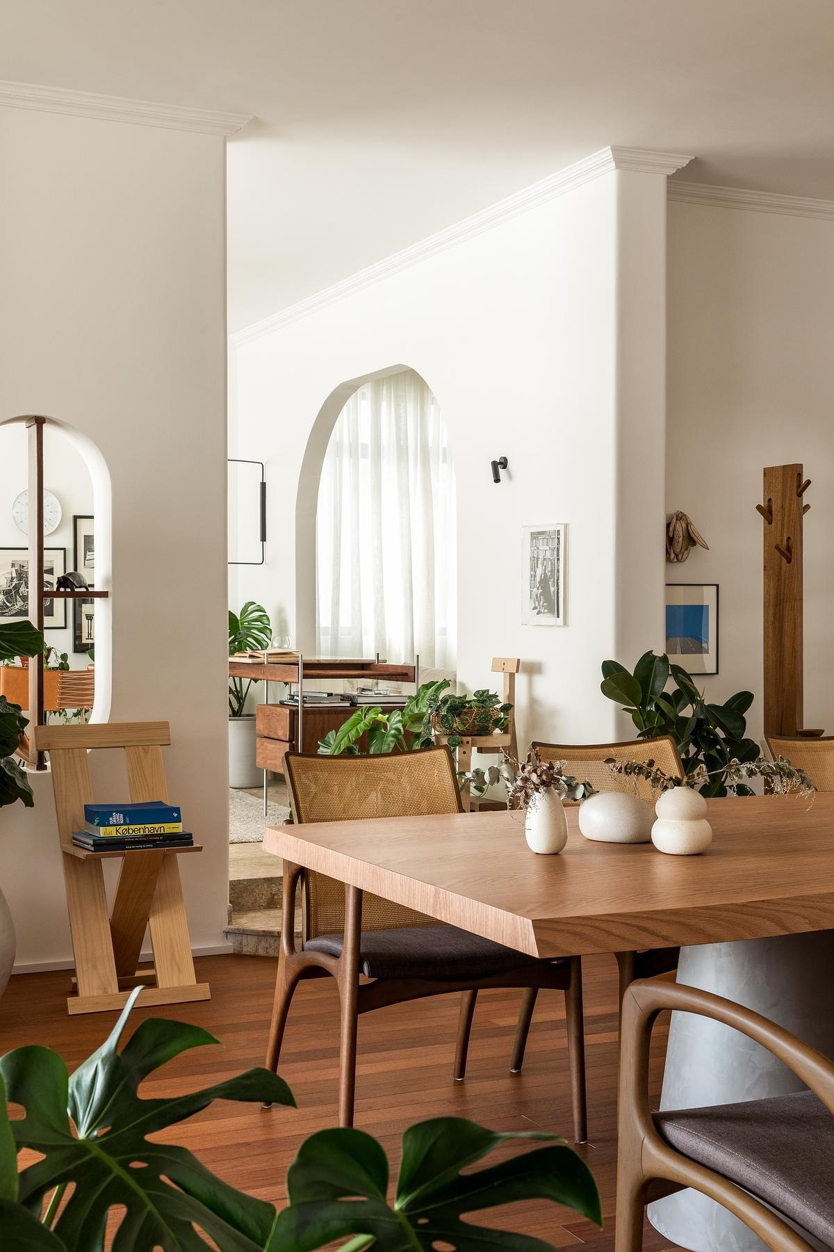 Lina Apartment by Alencar preserves its original 1980s arches and character while introducing Brazilian modernist furniture, flexible layouts, and three distinct living areas in a thoughtful renovation.