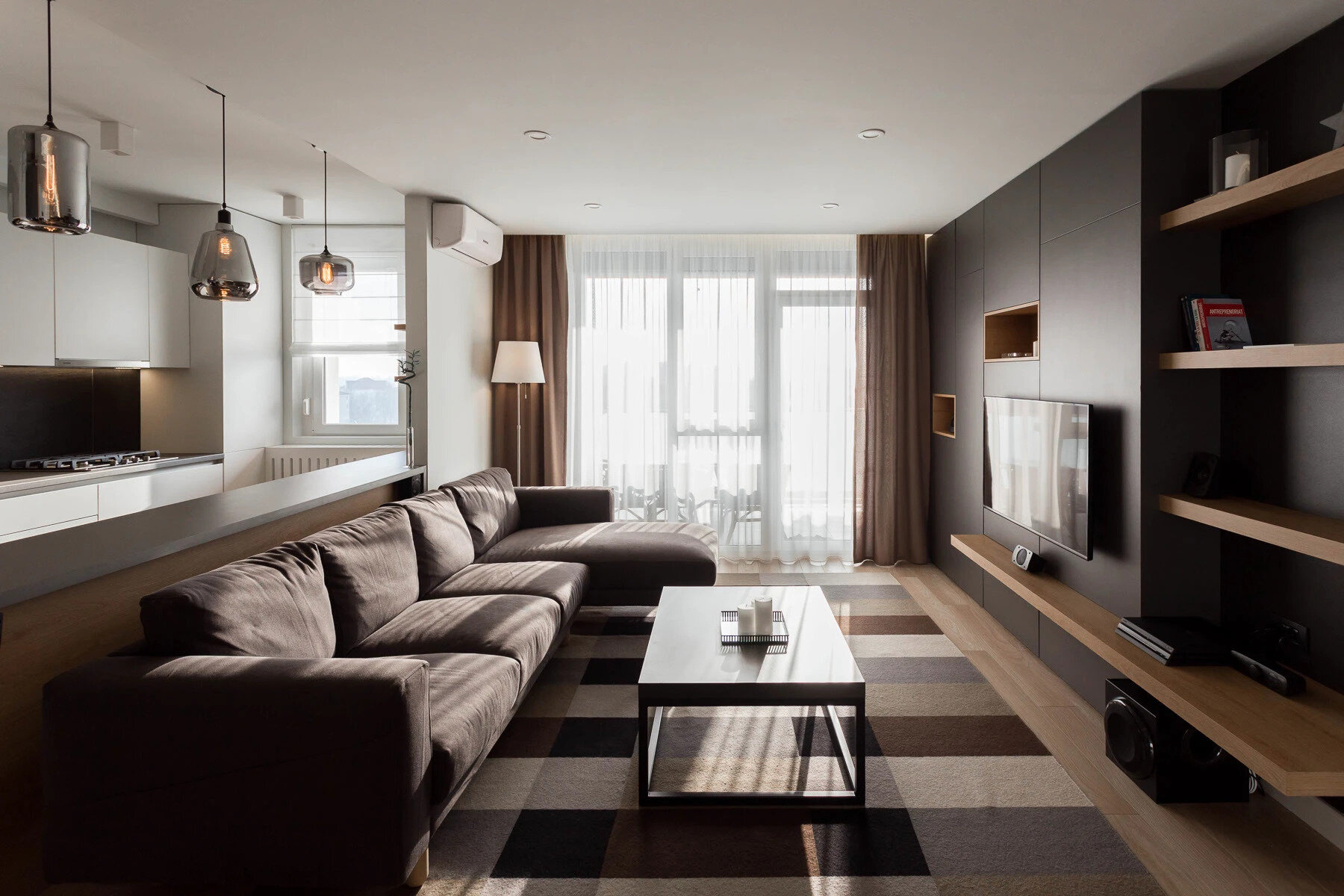 La sala de estar minimalista utiliza tonos cálidos de madera, paredes blancas y suaves tonos negros y grises para crear un espacio luminoso y tranquilo, perfecto para relajarse.