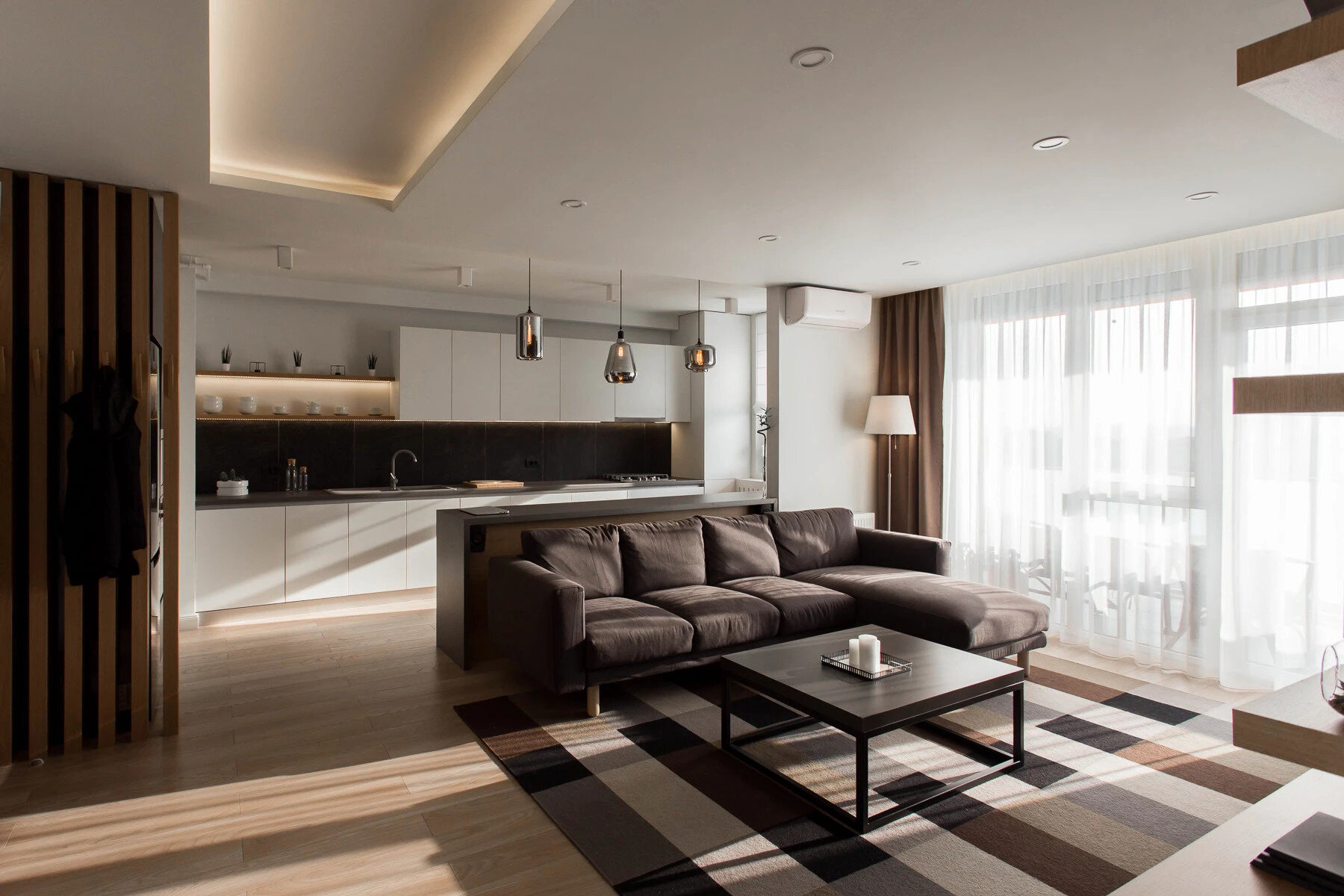 La sala de estar minimalista utiliza tonos cálidos de madera, paredes blancas y suaves tonos negros y grises para crear un espacio luminoso y tranquilo, perfecto para relajarse.