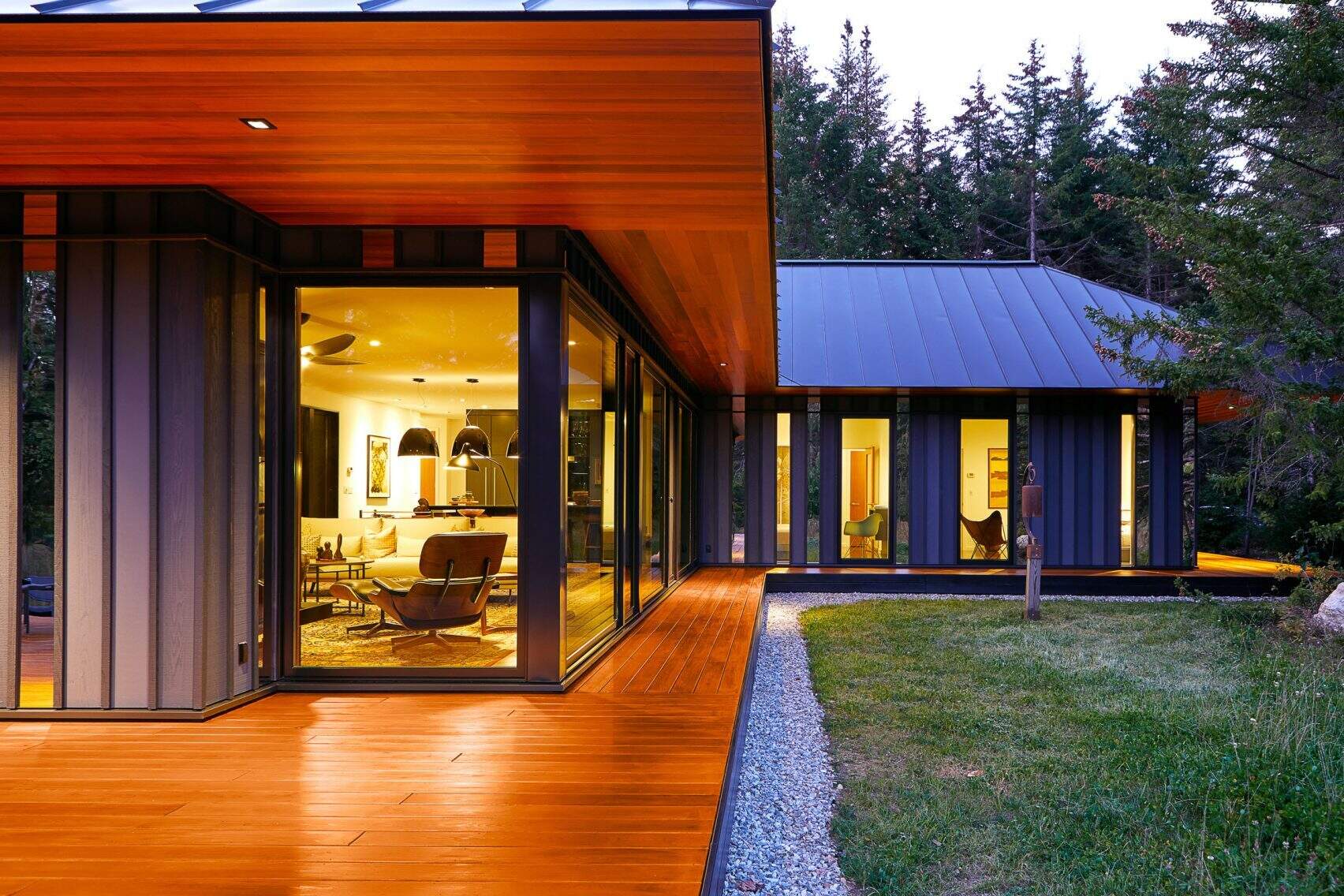 A secluded modern guest house in Vermont by Birdseye Design, featuring a razor-edged black roof and cedar soffits that blend effortlessly with the forest.