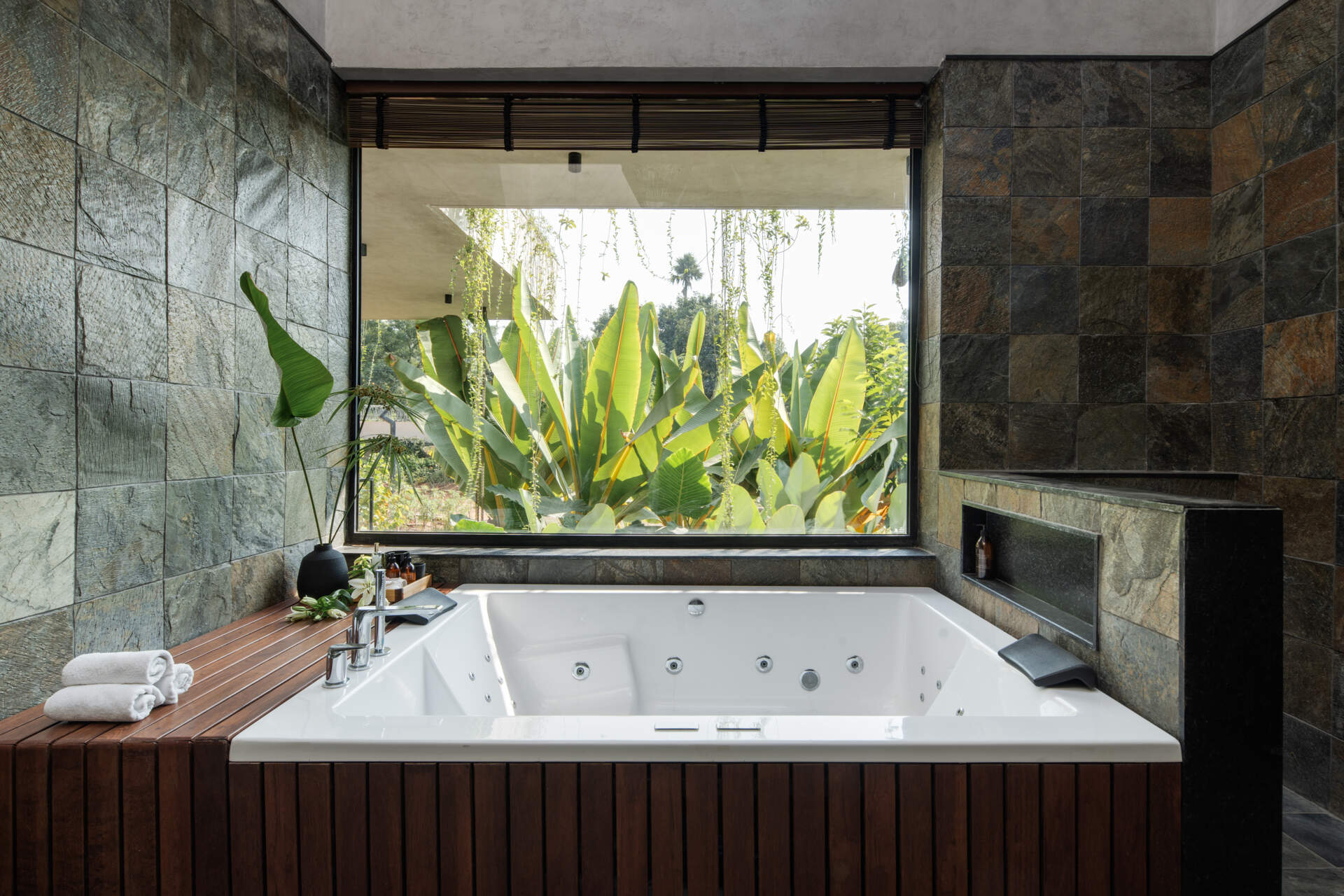 Stone tiled bathrooms that keep the palette natural and calm, echoing the home’s outdoor textures.