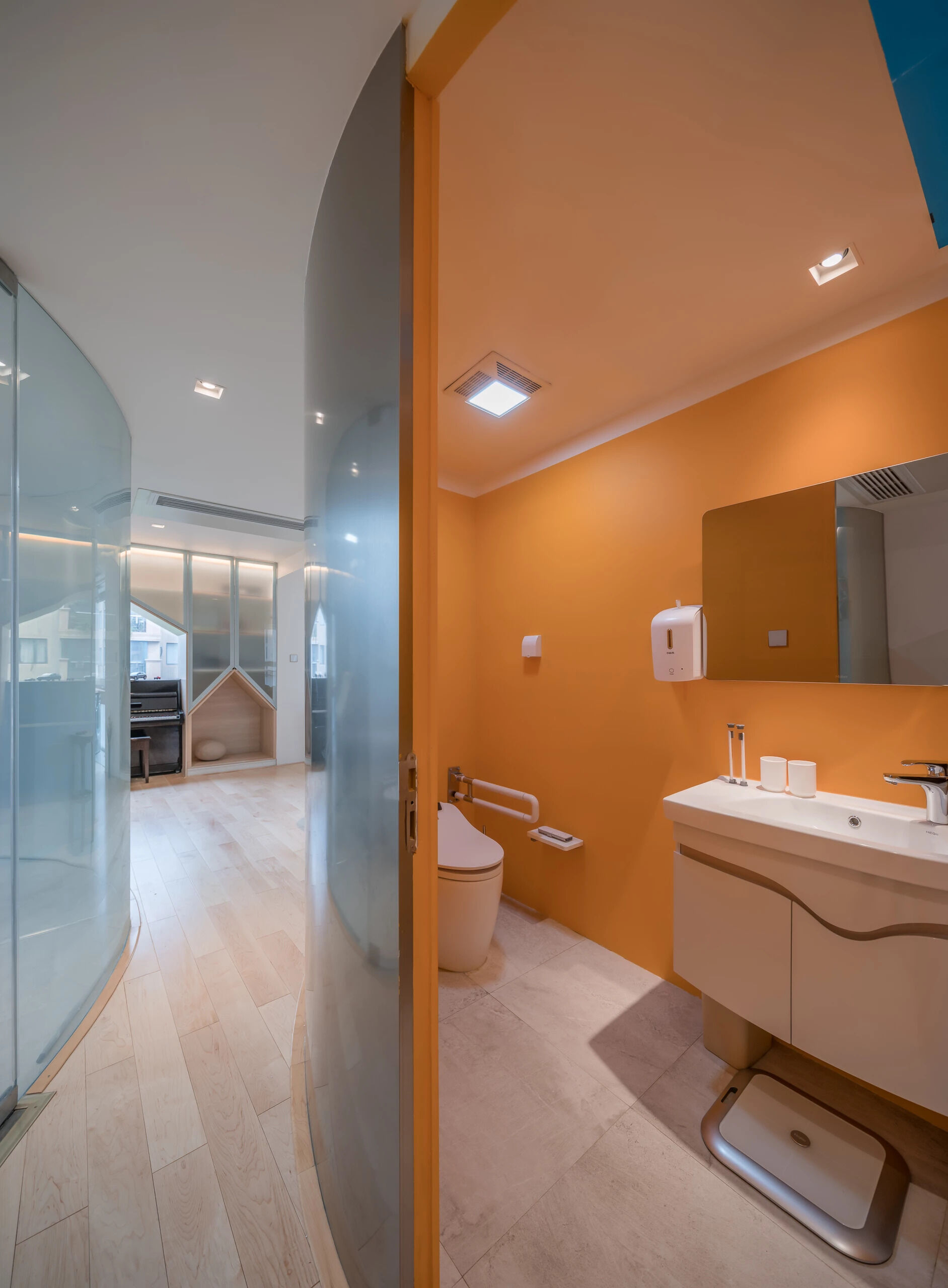 A pod-shaped bathroom with bright orange walls.