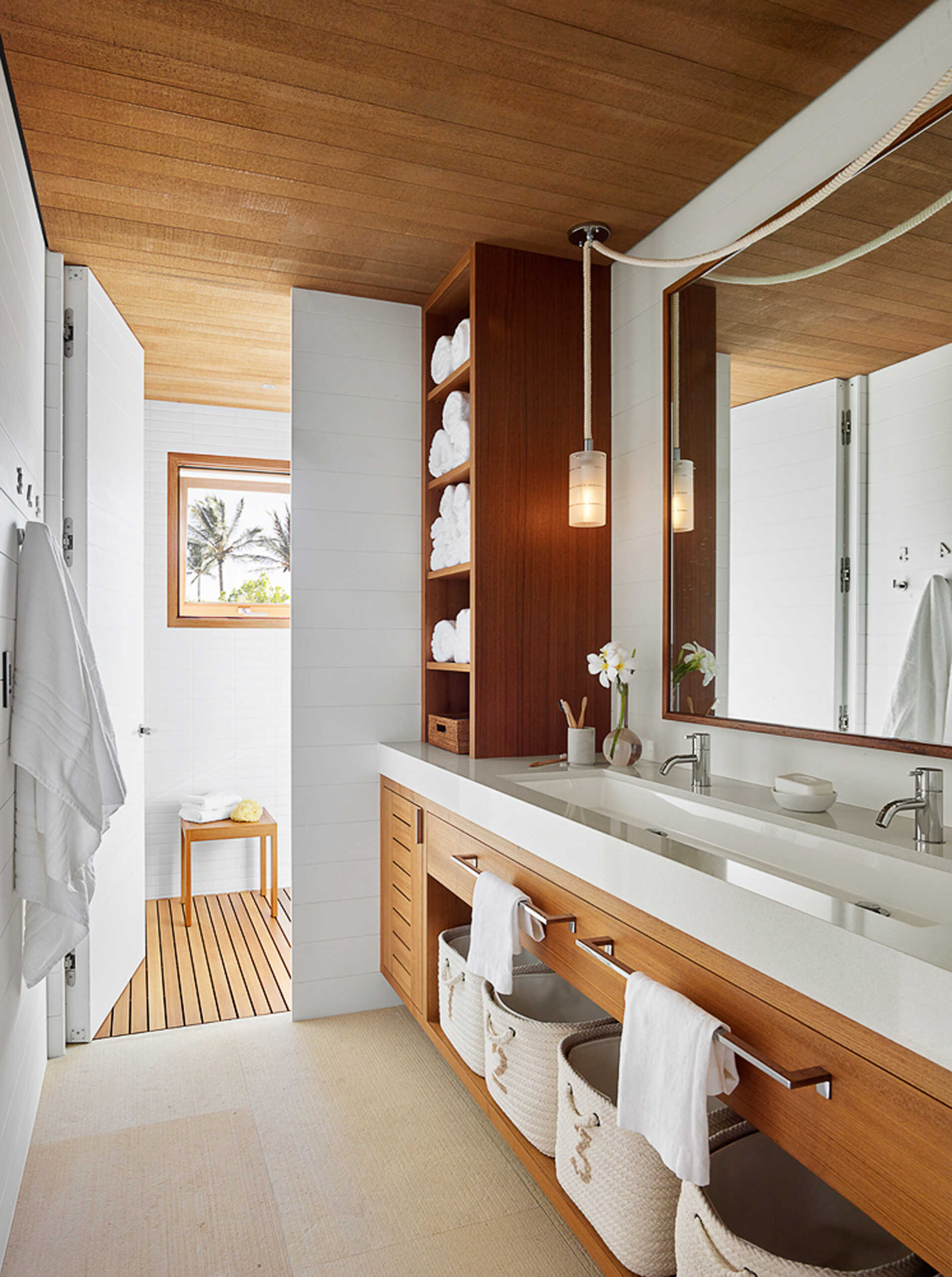 Spa-like bathrooms with ocean views and natural finishes define this Kauai home’s tranquil vibe.