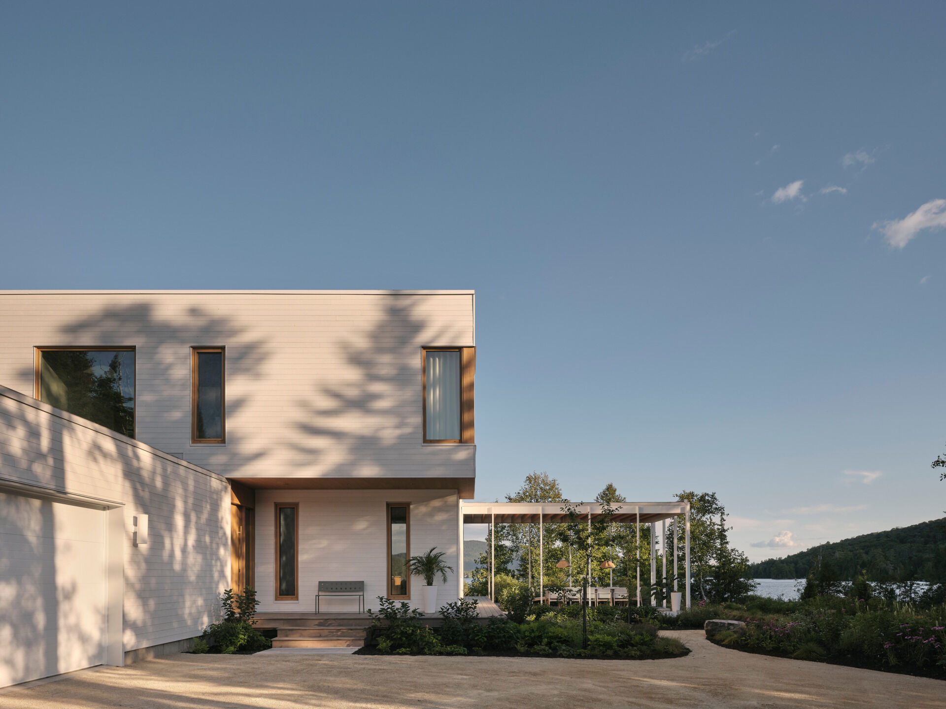 A minimalist Canadian lake house where white wood, sunlight, and water create a perfect balance.