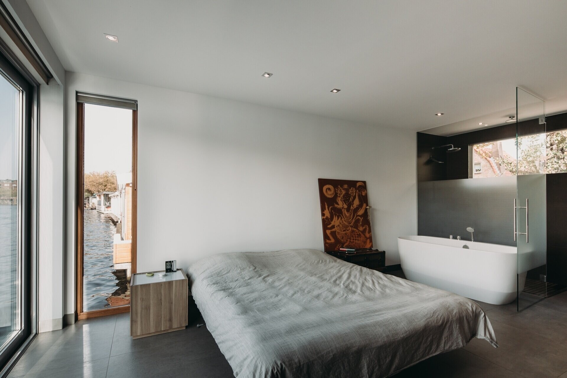 El dormitorio y el baño de la planta principal están diseñados como un espacio separado por una pared de vidrio parcialmente esmerilado que permite el paso de la luz.