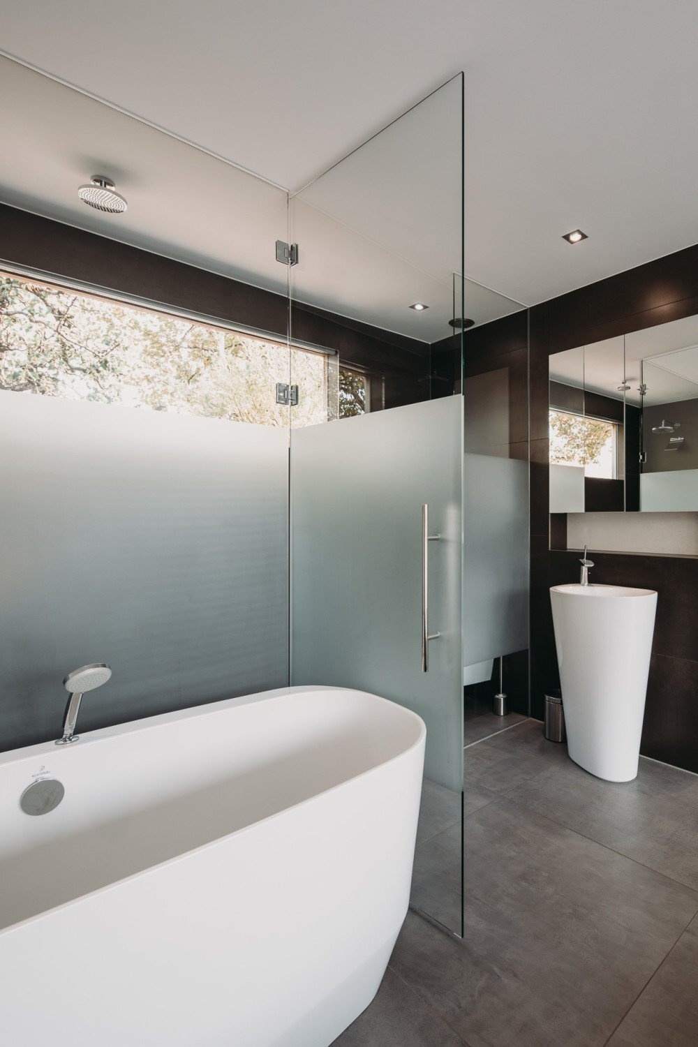 El dormitorio y el baño de la planta principal están diseñados como un espacio separado por una pared de vidrio parcialmente esmerilado que permite el paso de la luz.